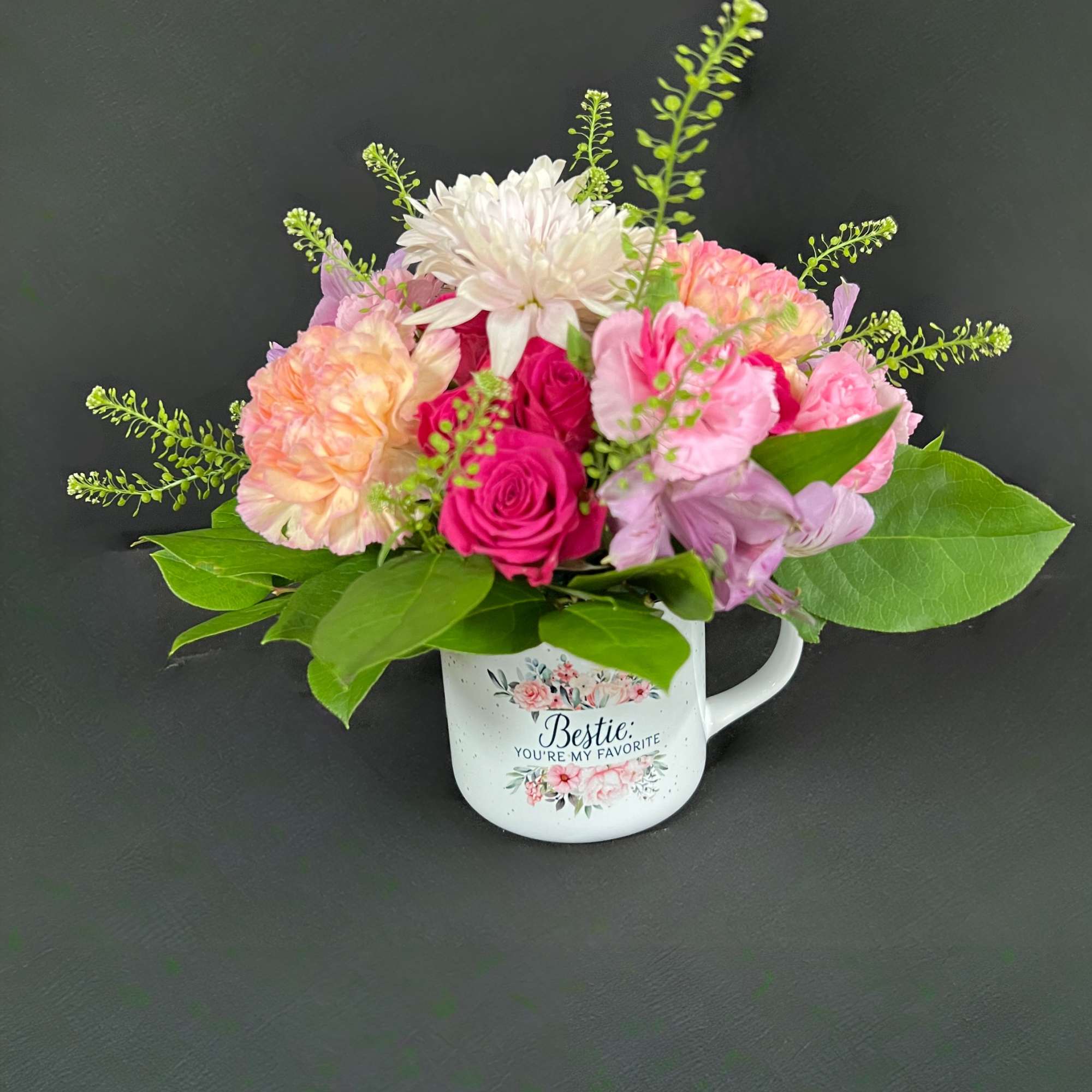 Pink and white flower arrangement in a decorative mug
