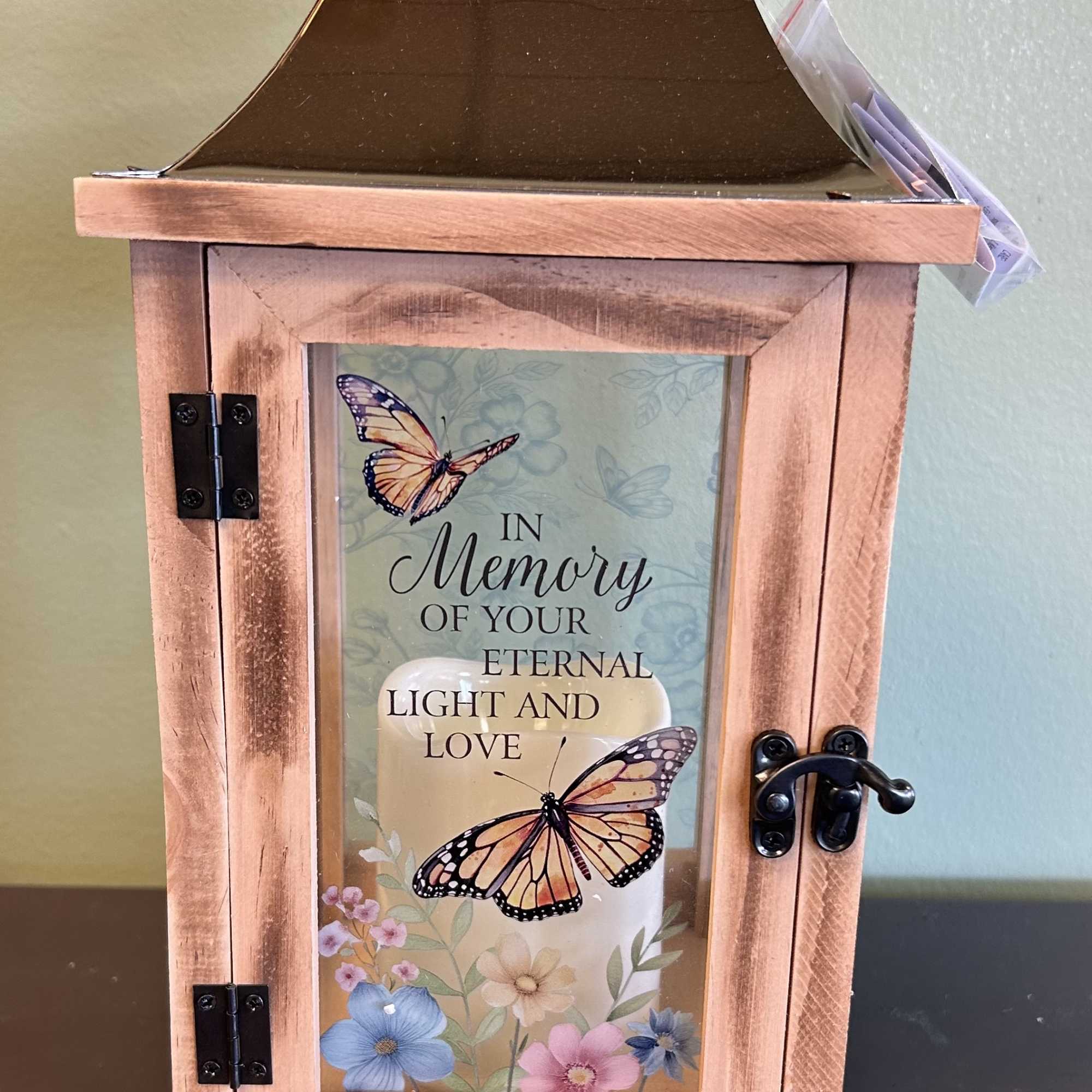 Wooden memorial lantern with butterfly artwork and a candle inside