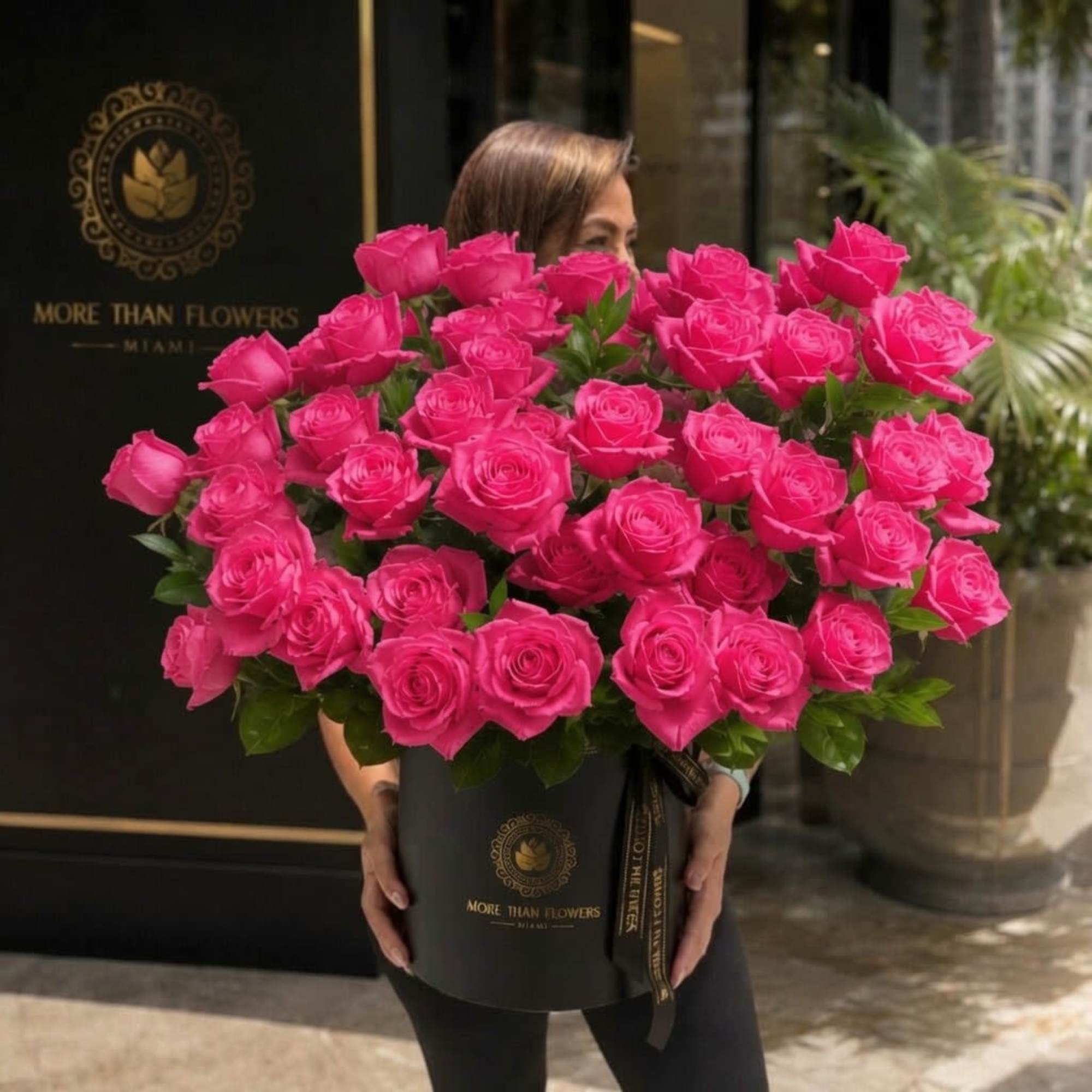 A dramatic cluster of forty reflexed hot pink roses arranged low and