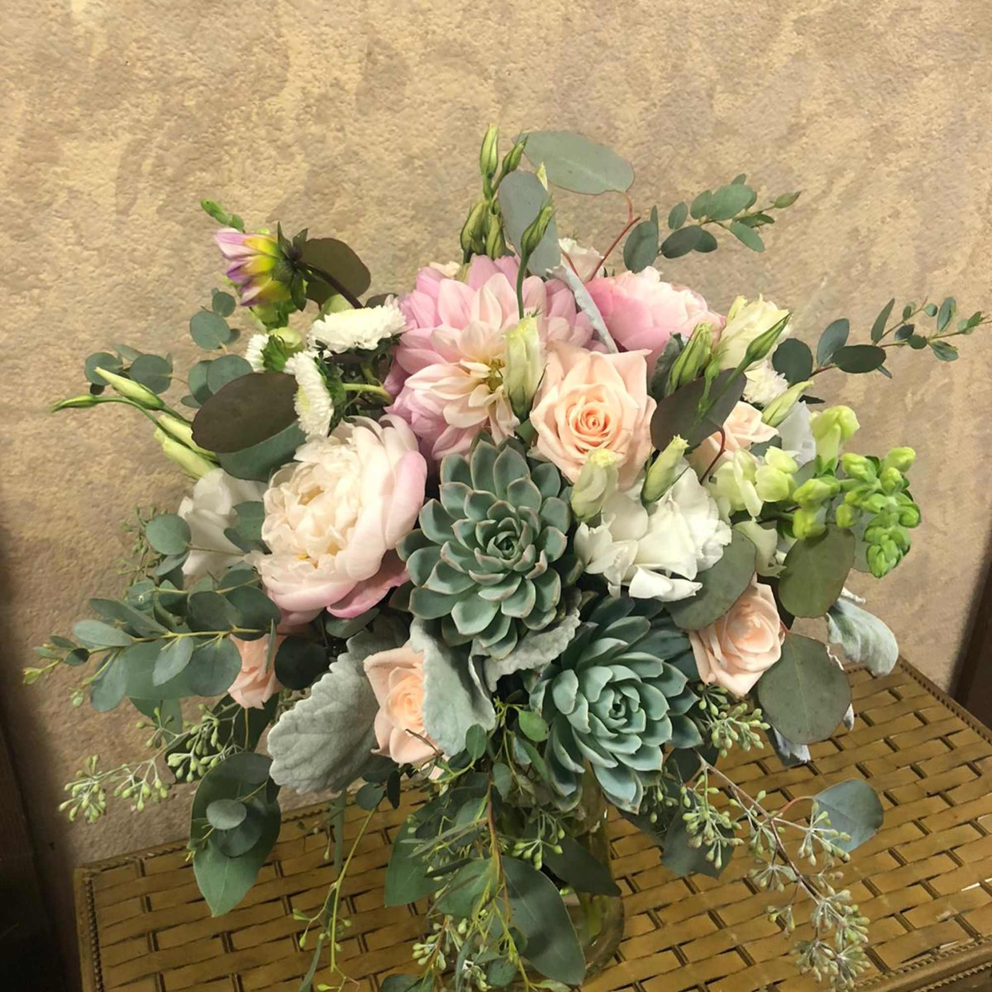 Bouquet of blush roses, pink blooms, and succulents with eucalyptus