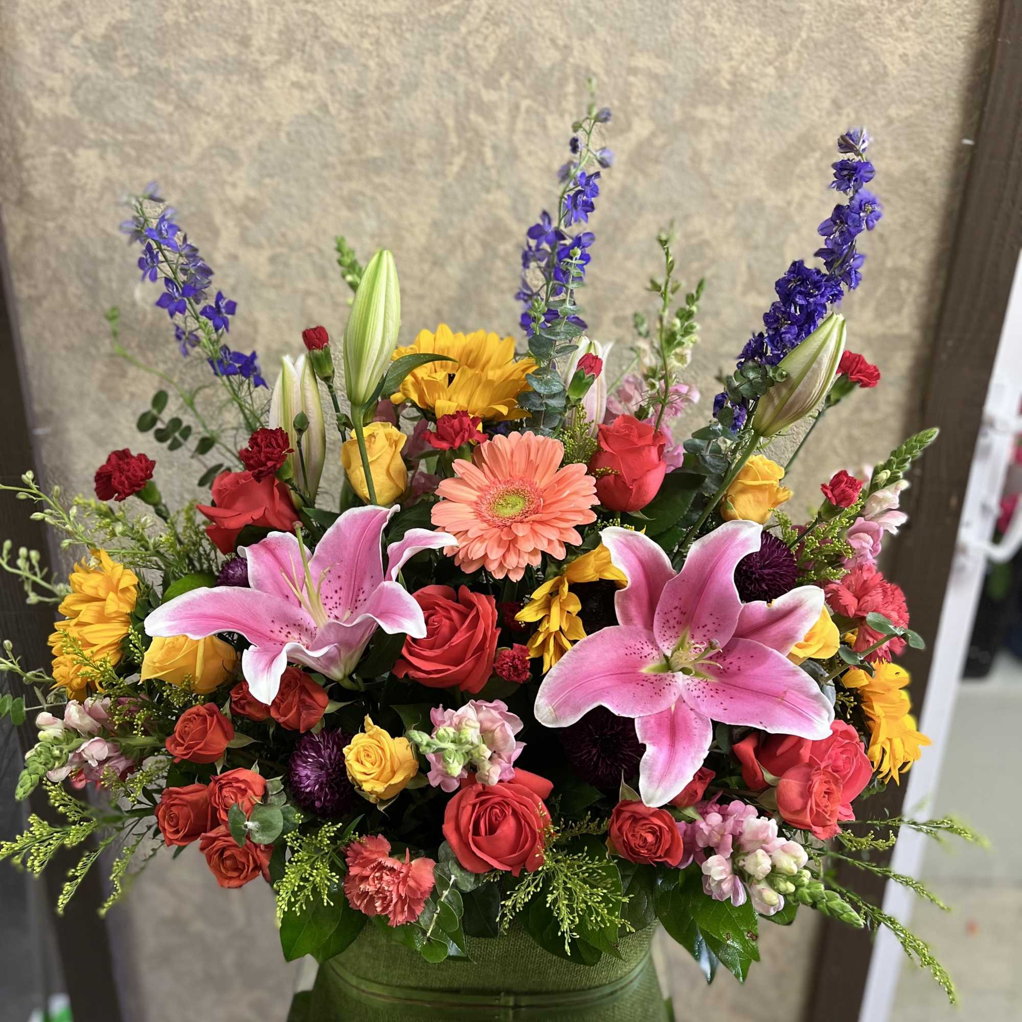 Colorful mixed bouquet with pink lilies, roses, and gerbera daisies in a vase
