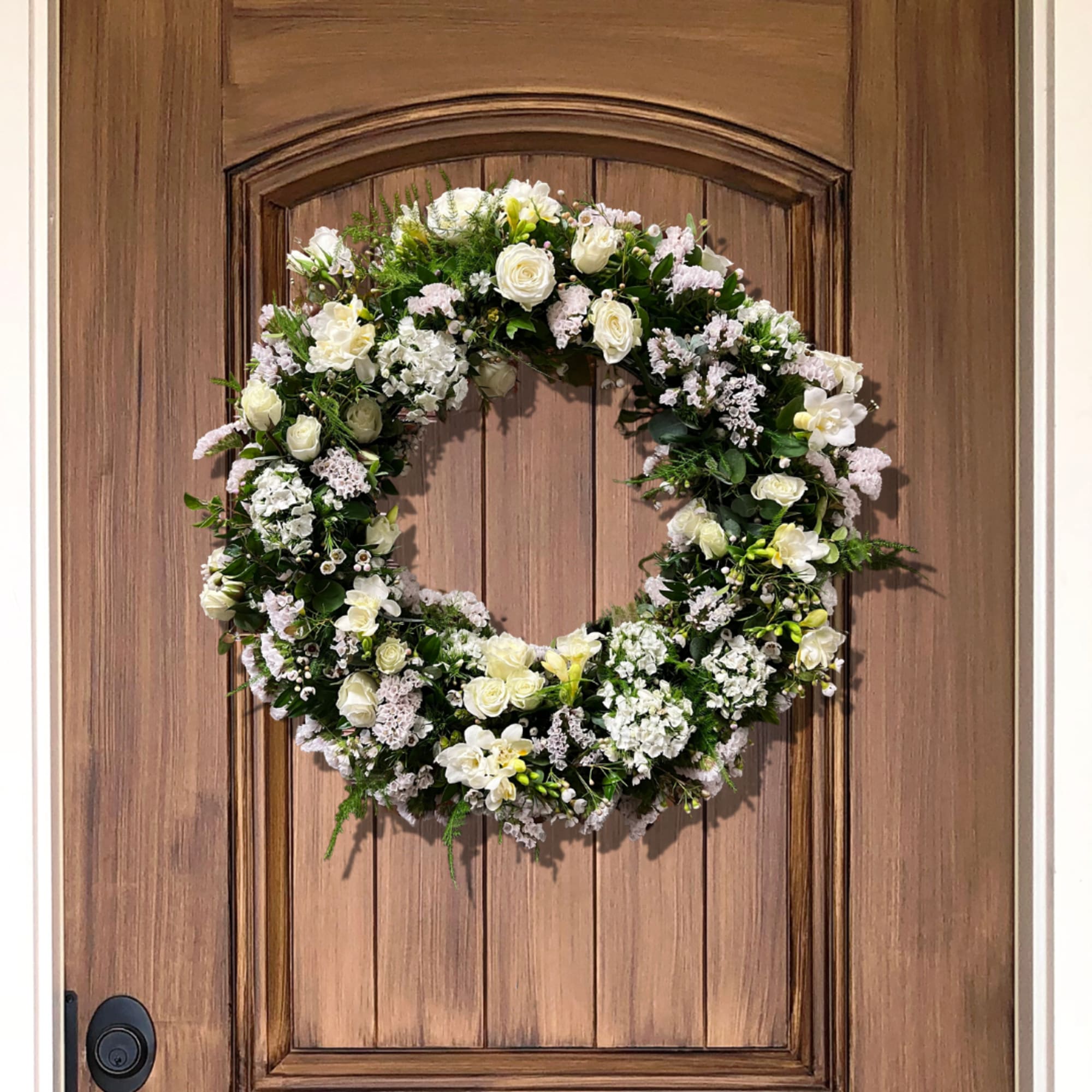 White floral wreath on a wooden door