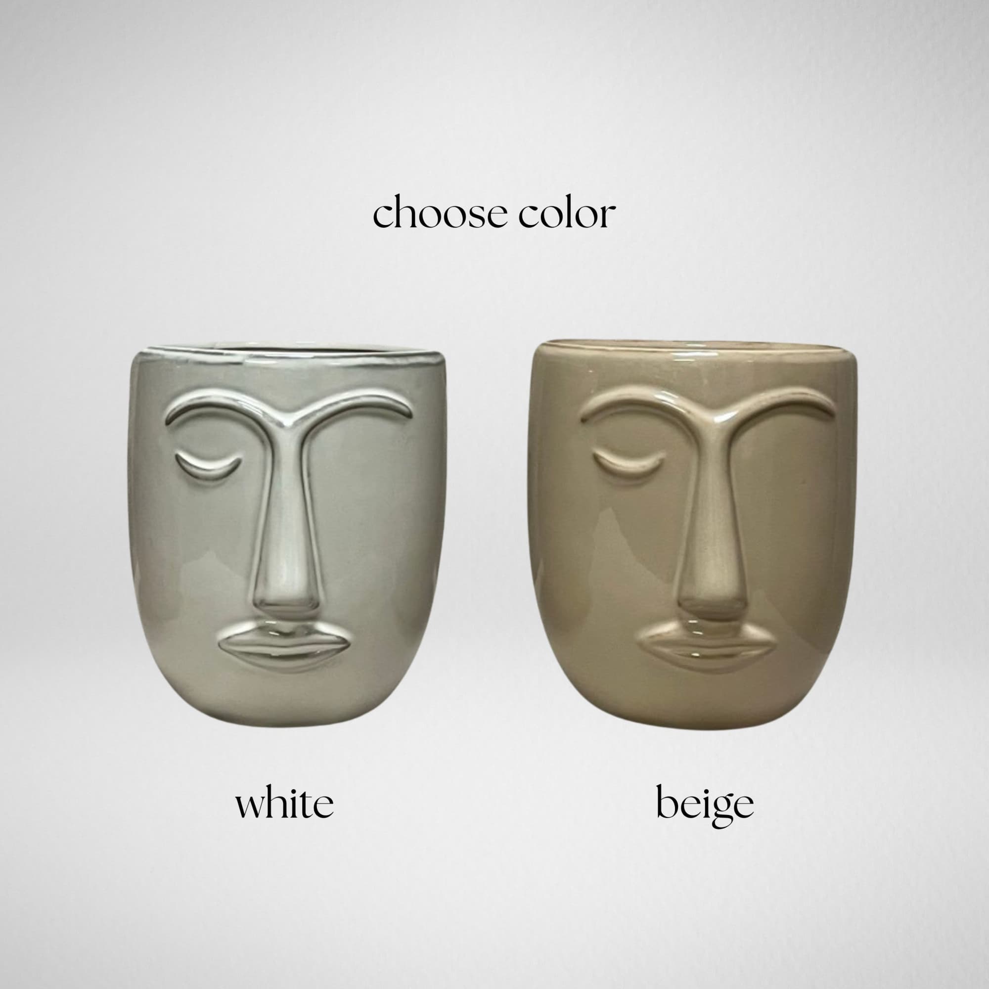 Two face-shaped ceramic candle holders in white and beige