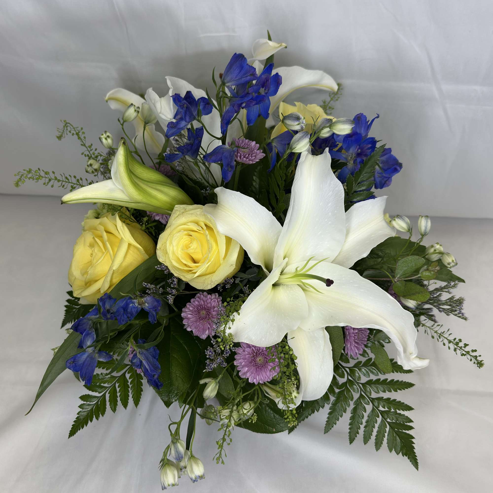 Bouquet with white lilies, yellow roses, and blue flowers