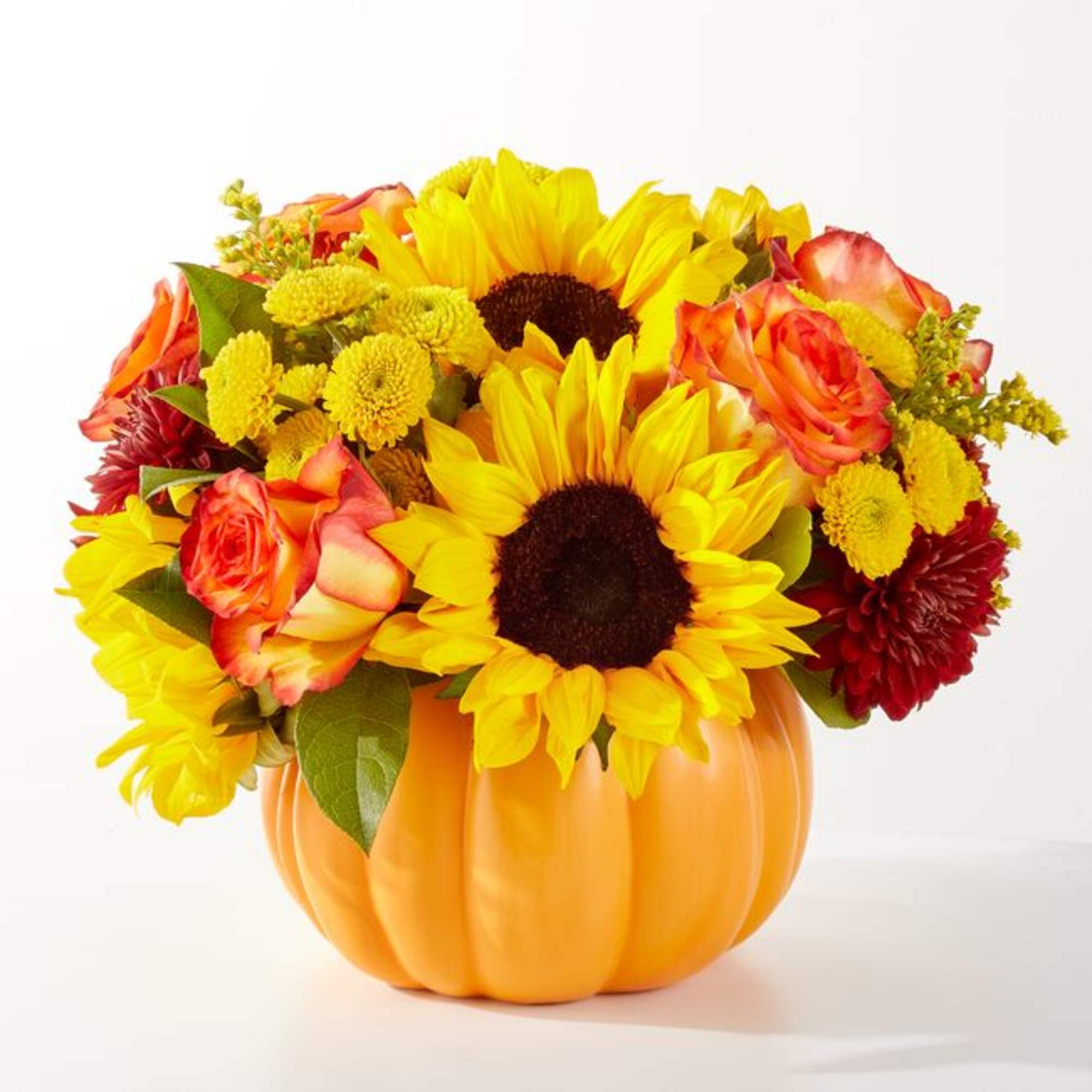 Sunflowers and orange roses arranged in a pumpkin-shaped container