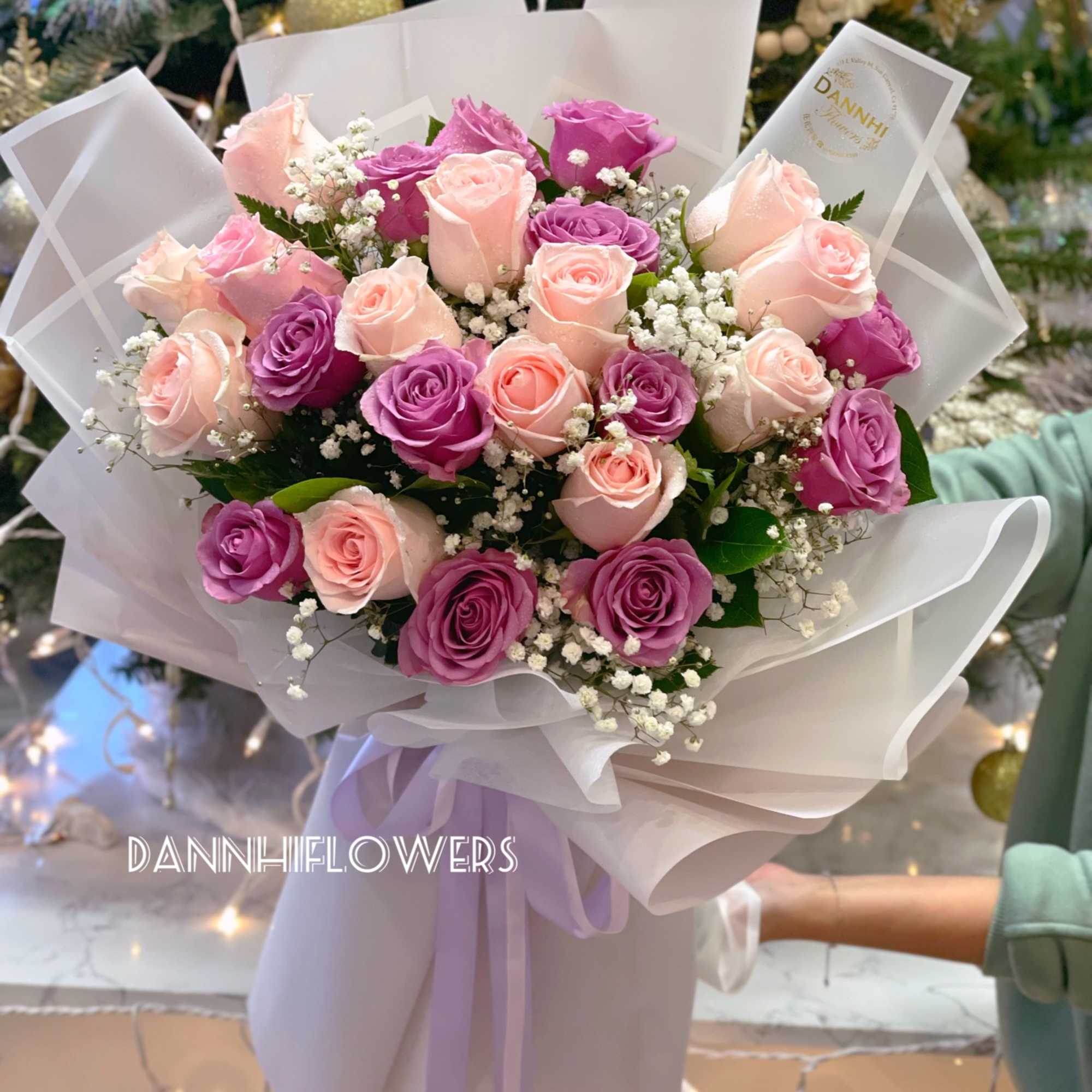Bouquet of pink and purple roses wrapped in white paper