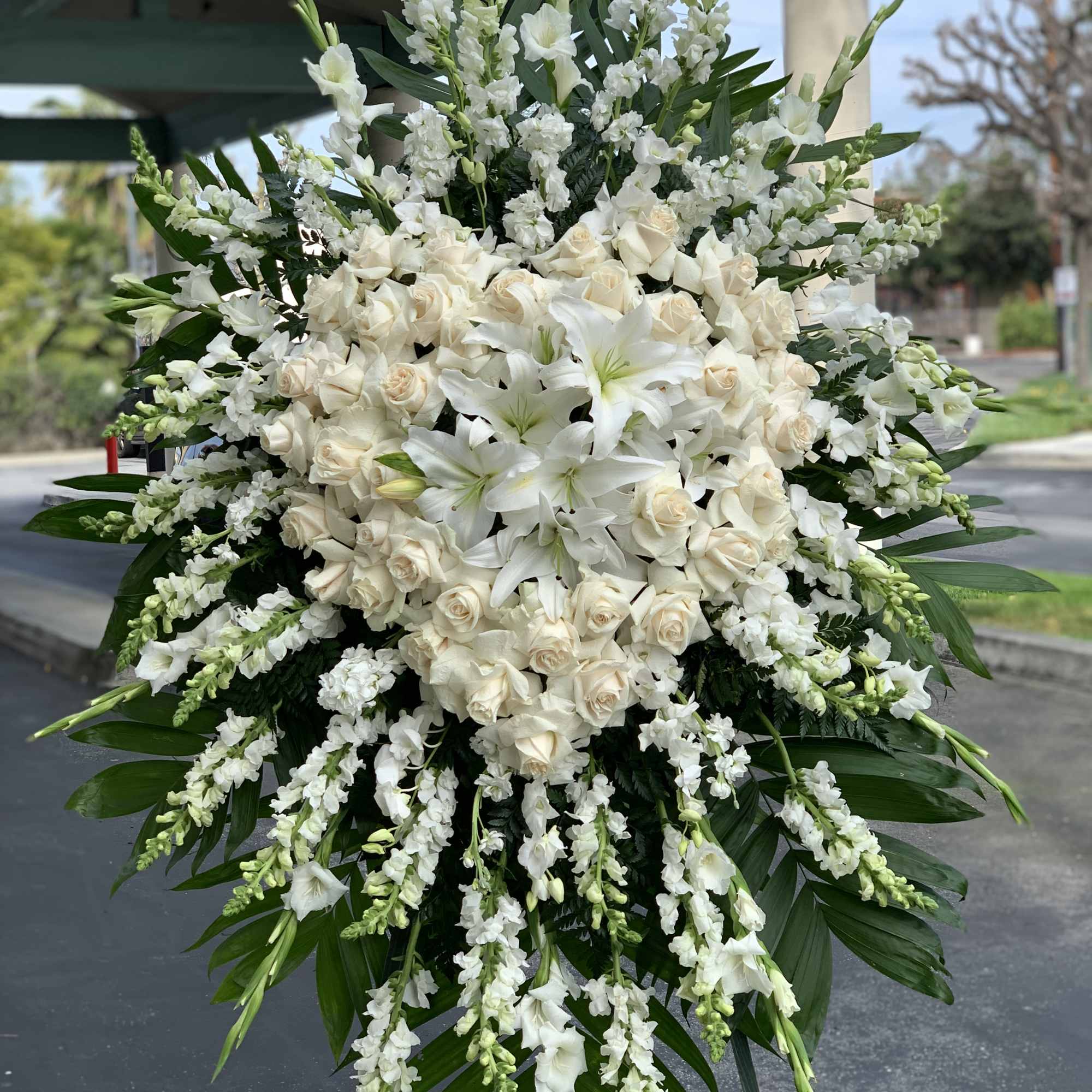 Large white funeral spray with roses and lilies