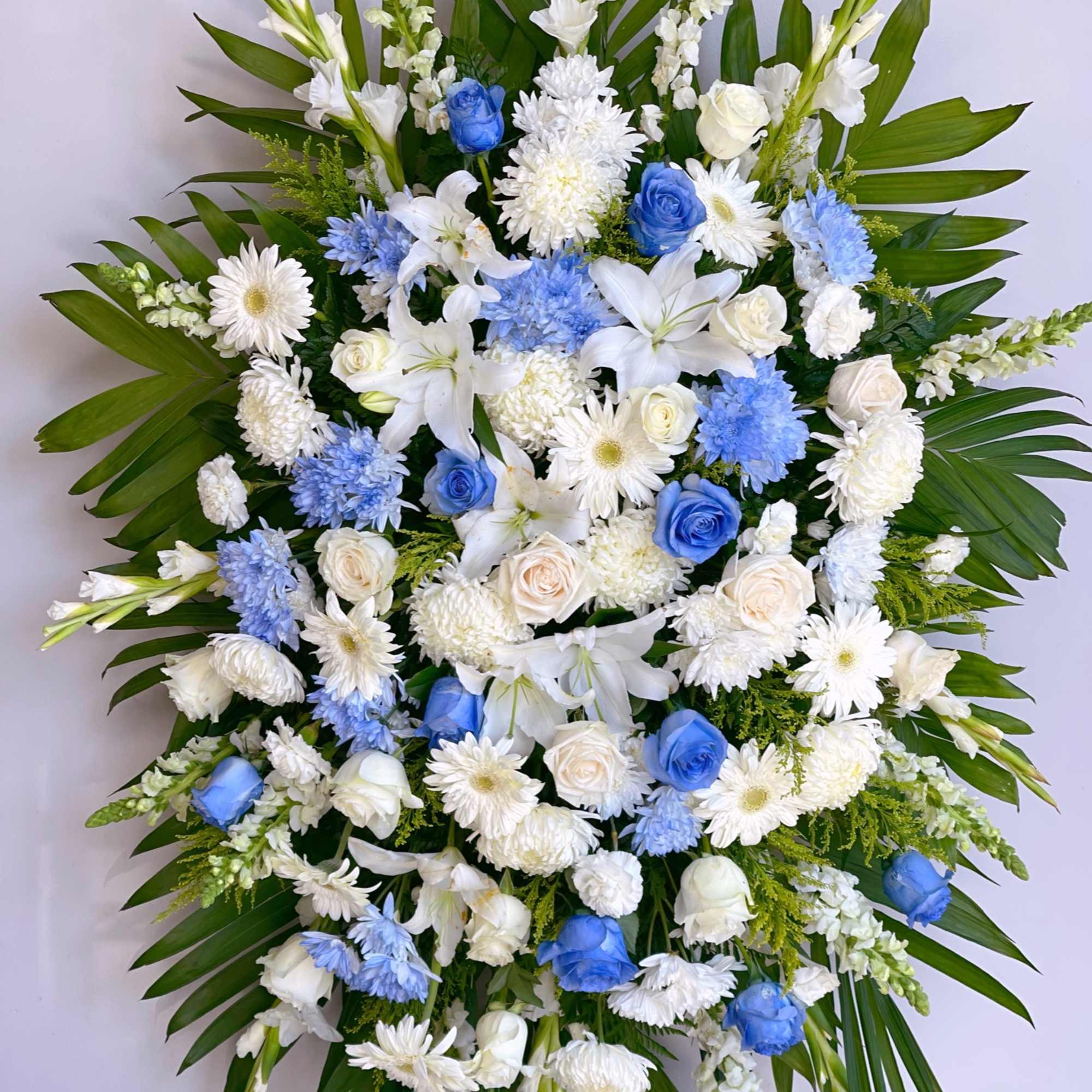 Large white and blue floral spray with palm leaves