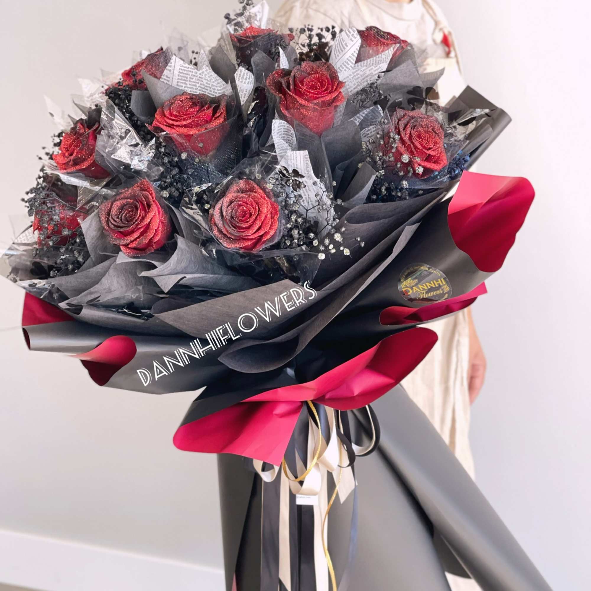 Bouquet of red roses wrapped in black and pink paper