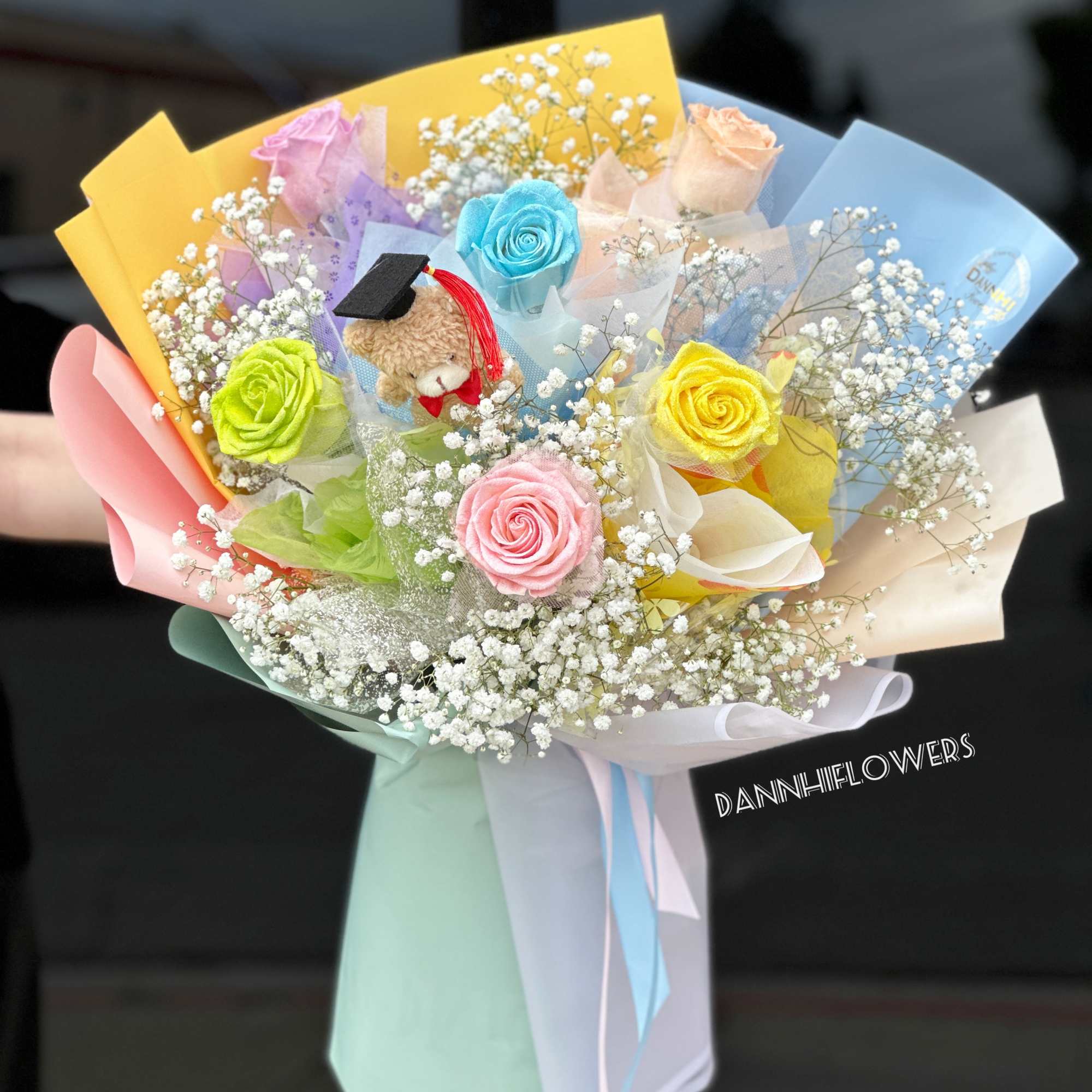 Colorful bouquet with roses, baby’s breath, and a small teddy bear