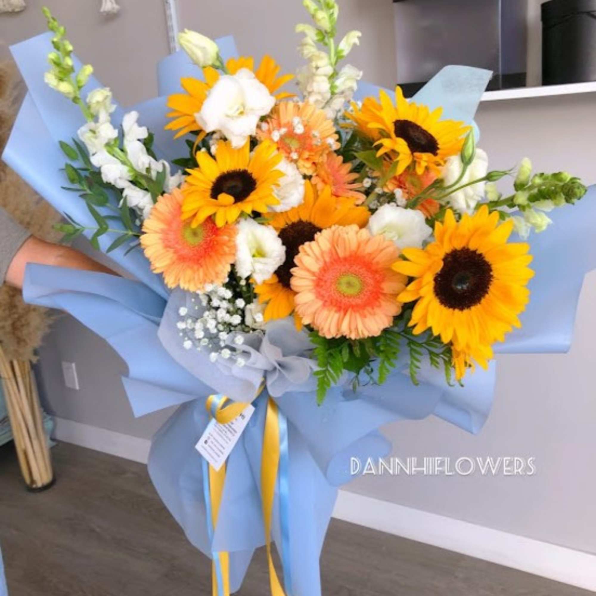 Mix flowers bouquet of sunflowers, gerbera daisy and lisianthus, wrap with light