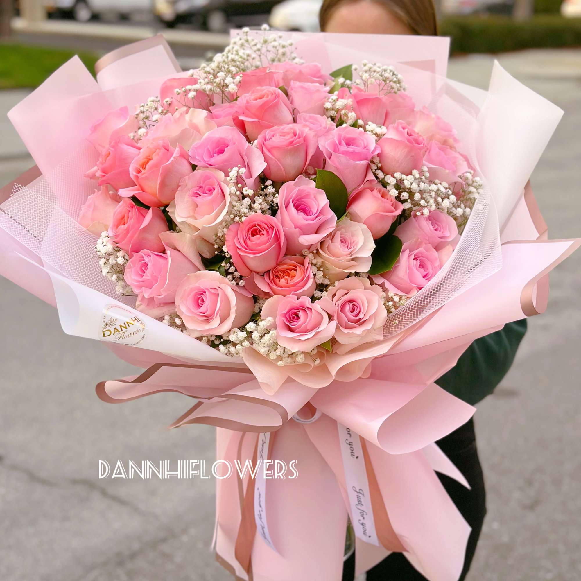 Large bouquet of pink roses wrapped in pale pink paper