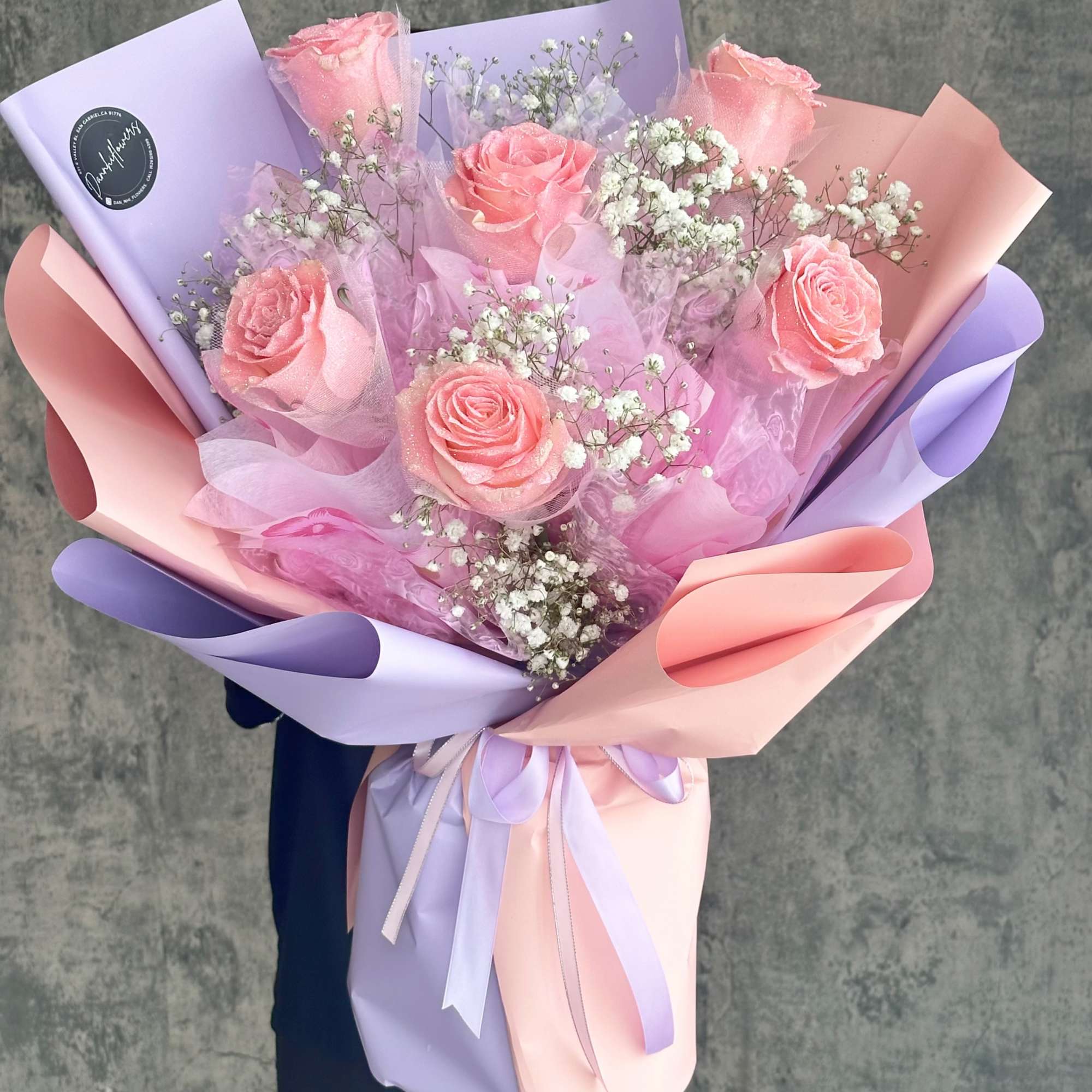 Pink roses with baby's breath in pastel lavender and peach wrapping