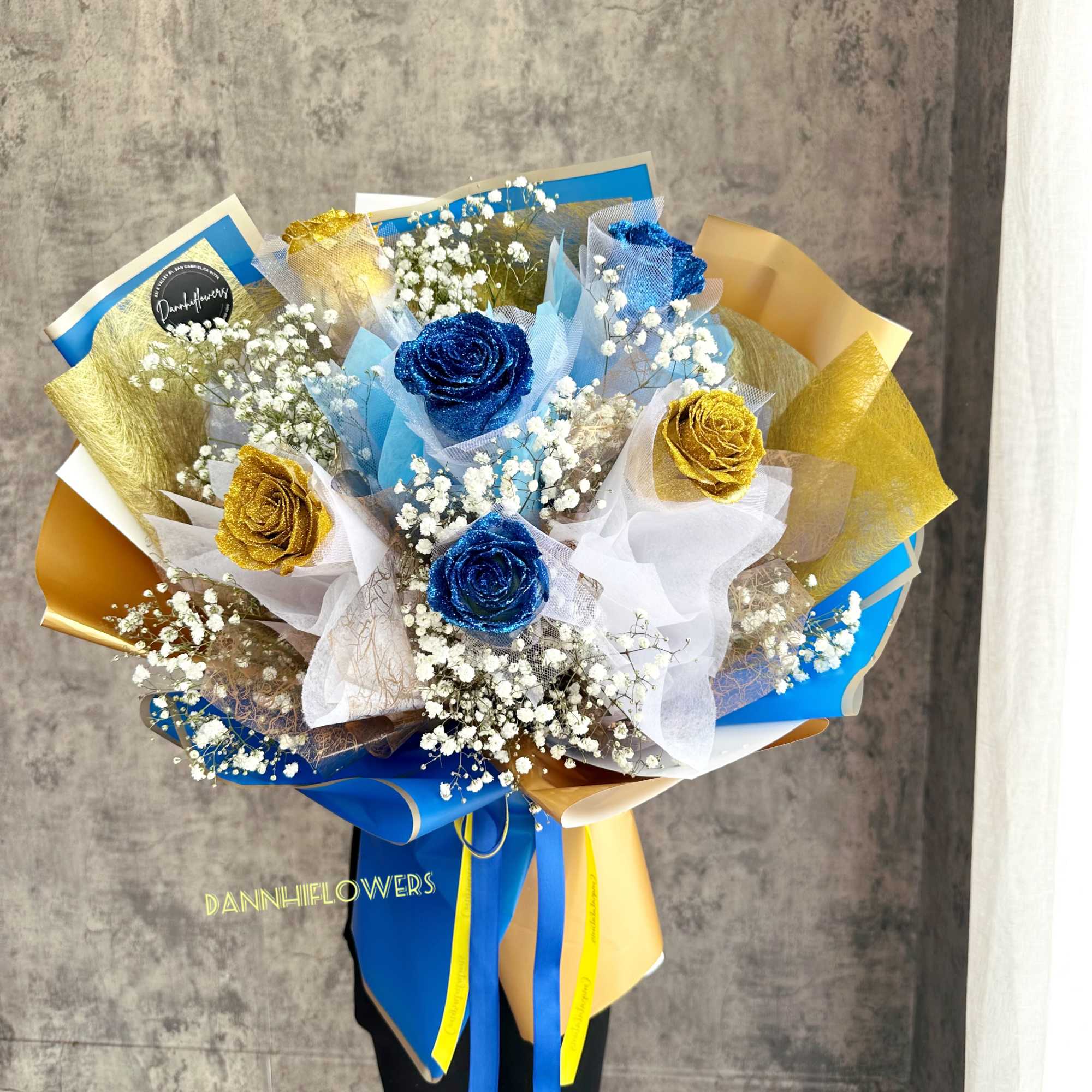 Bouquet of blue and gold roses with white baby's breath