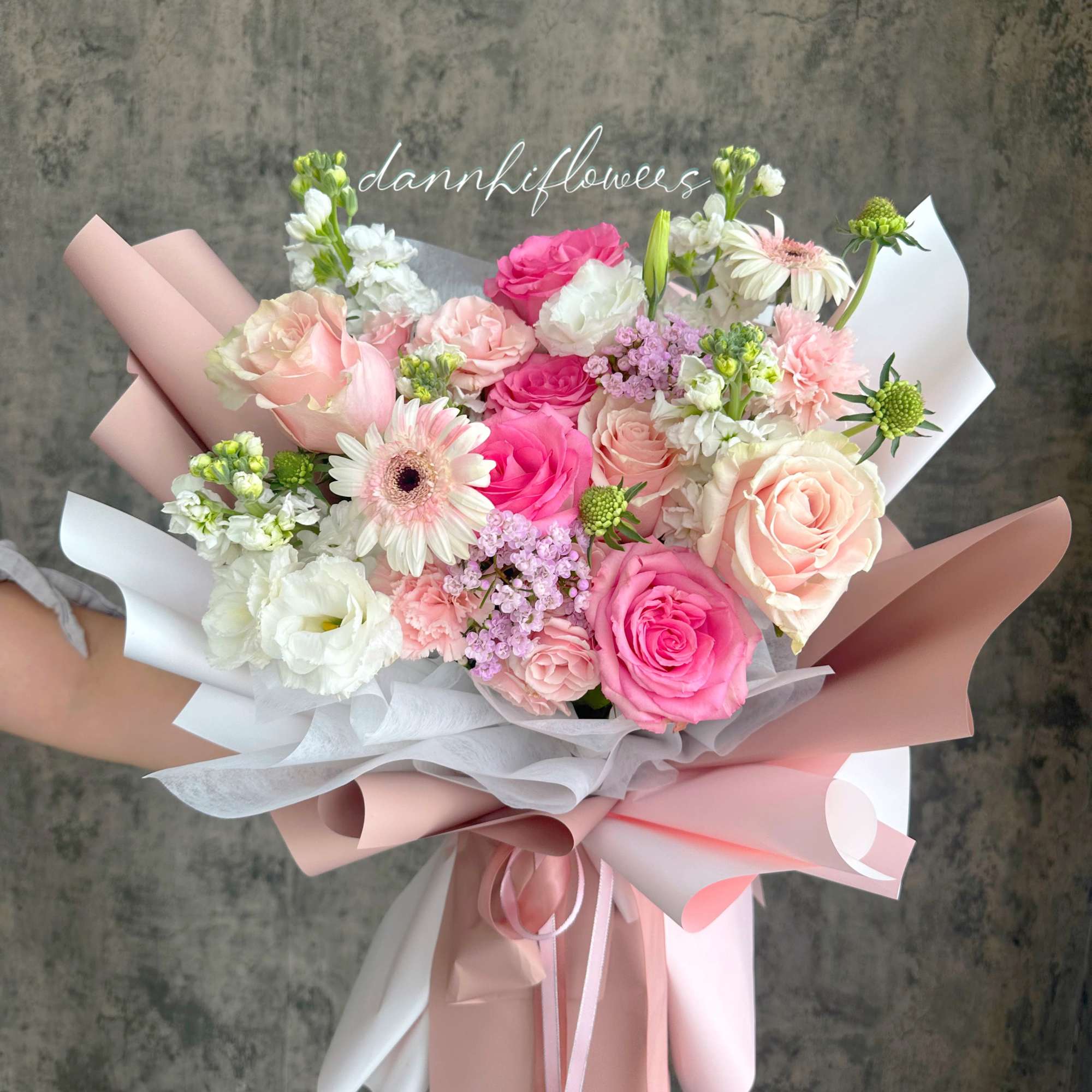 Hand-tied bouquet of pink and white roses with gerbera daisies