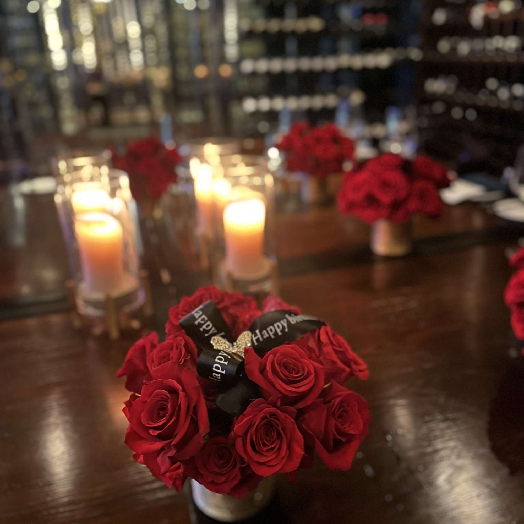 Red rose bouquet with candles on a table