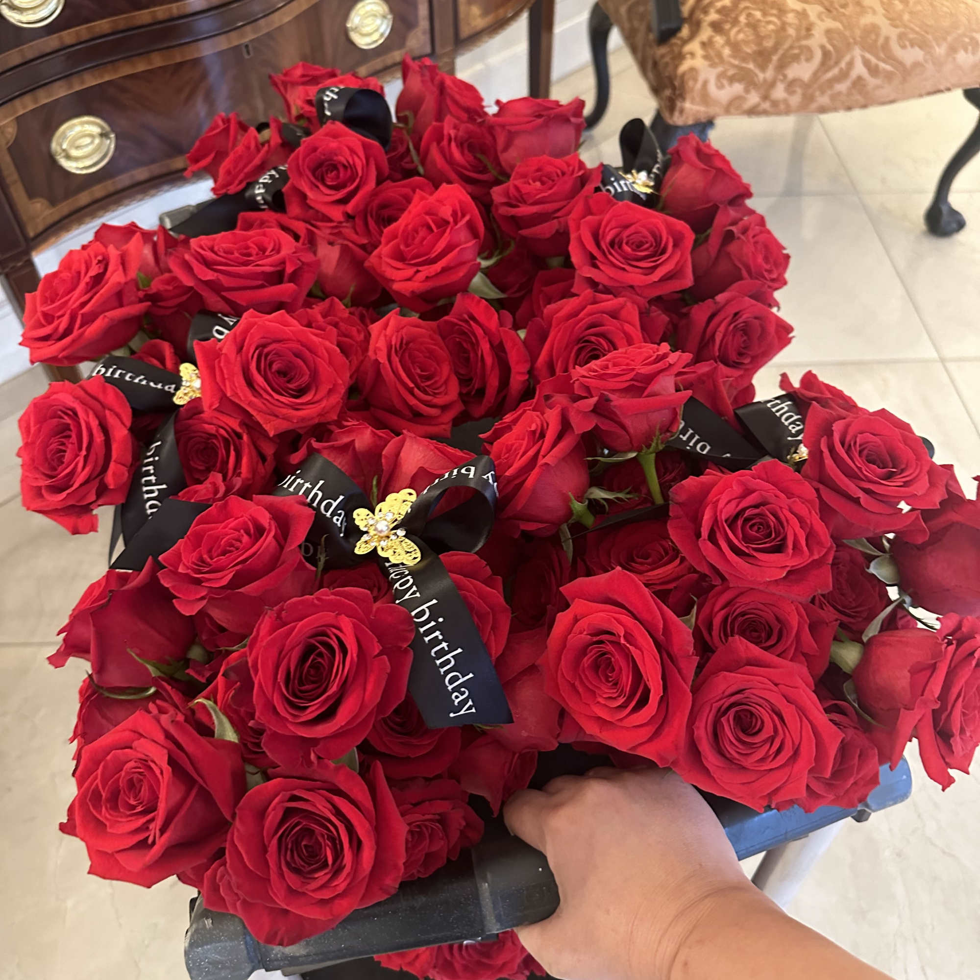 Large bouquet of red roses with black birthday ribbons