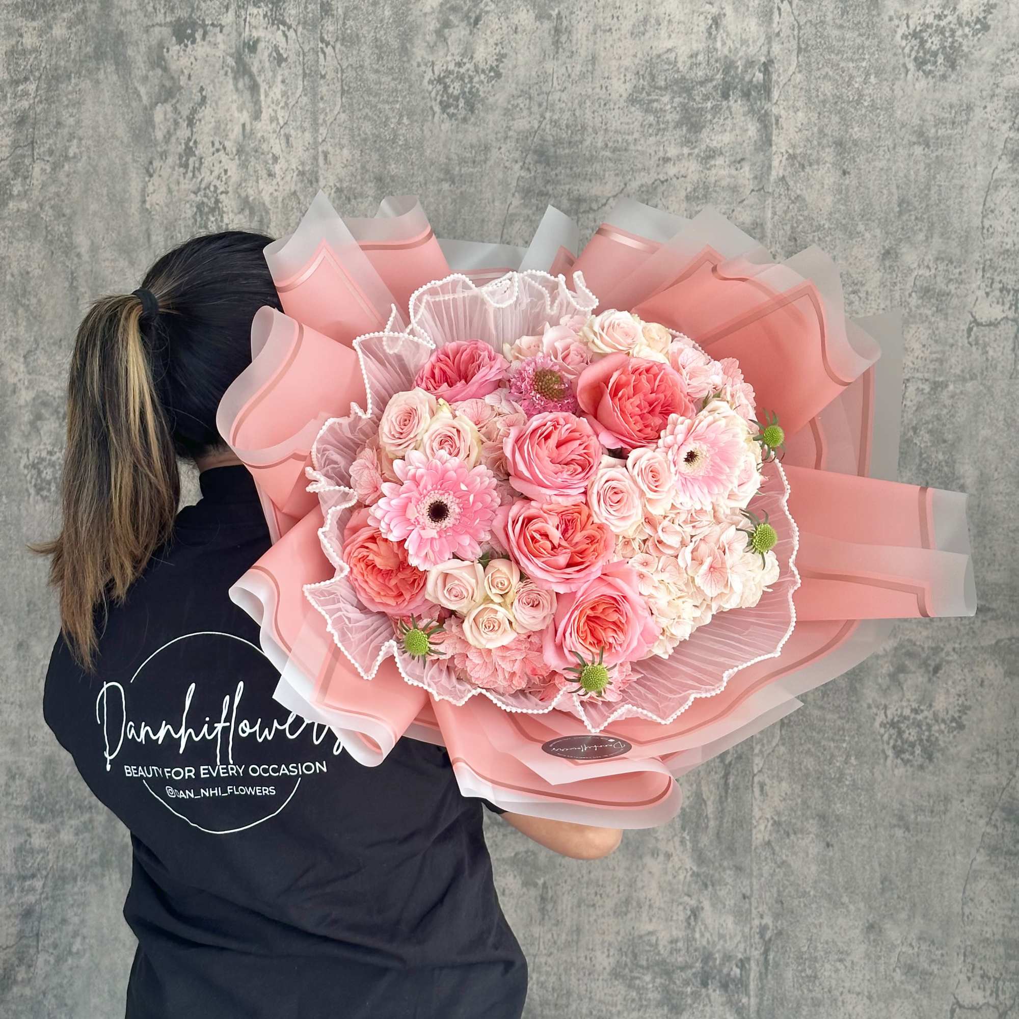 Large pink bouquet of roses and gerbera daisies wrapped in pink paper