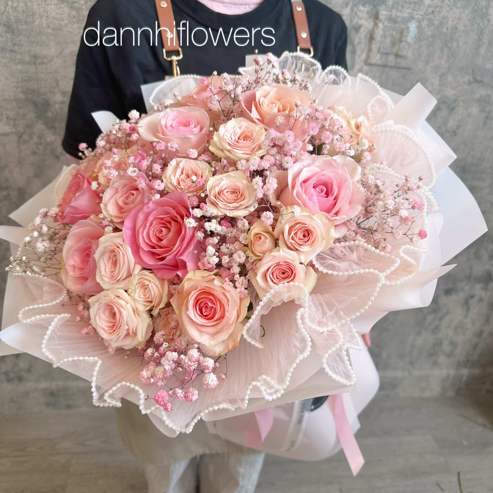 Large bouquet of pink and peach roses wrapped in pale pink paper