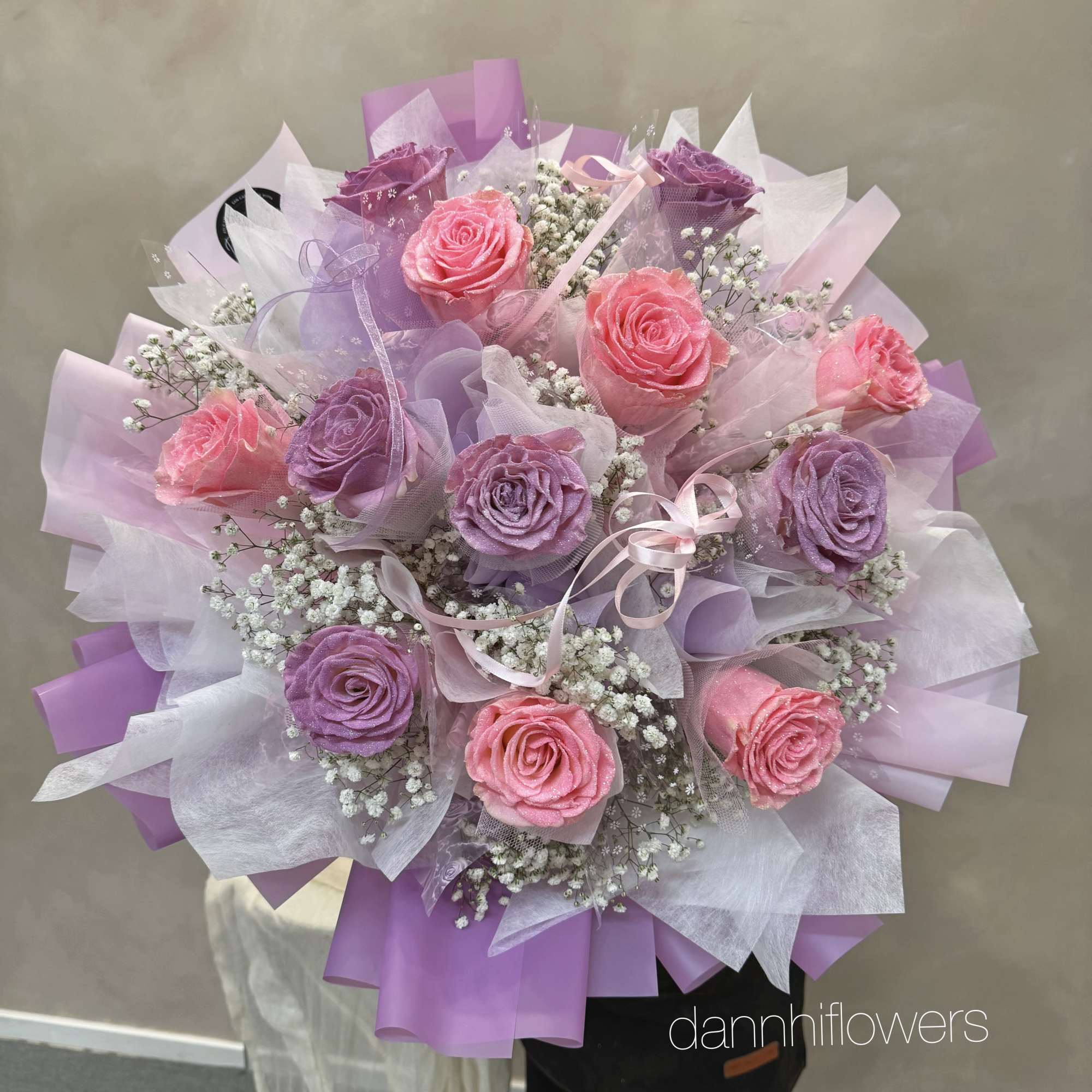 Bouquet of pink and purple roses wrapped in lavender paper