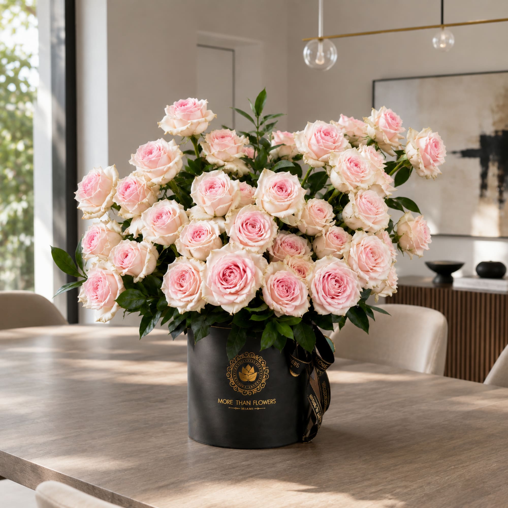 Large bouquet of pale pink roses in a black hatbox