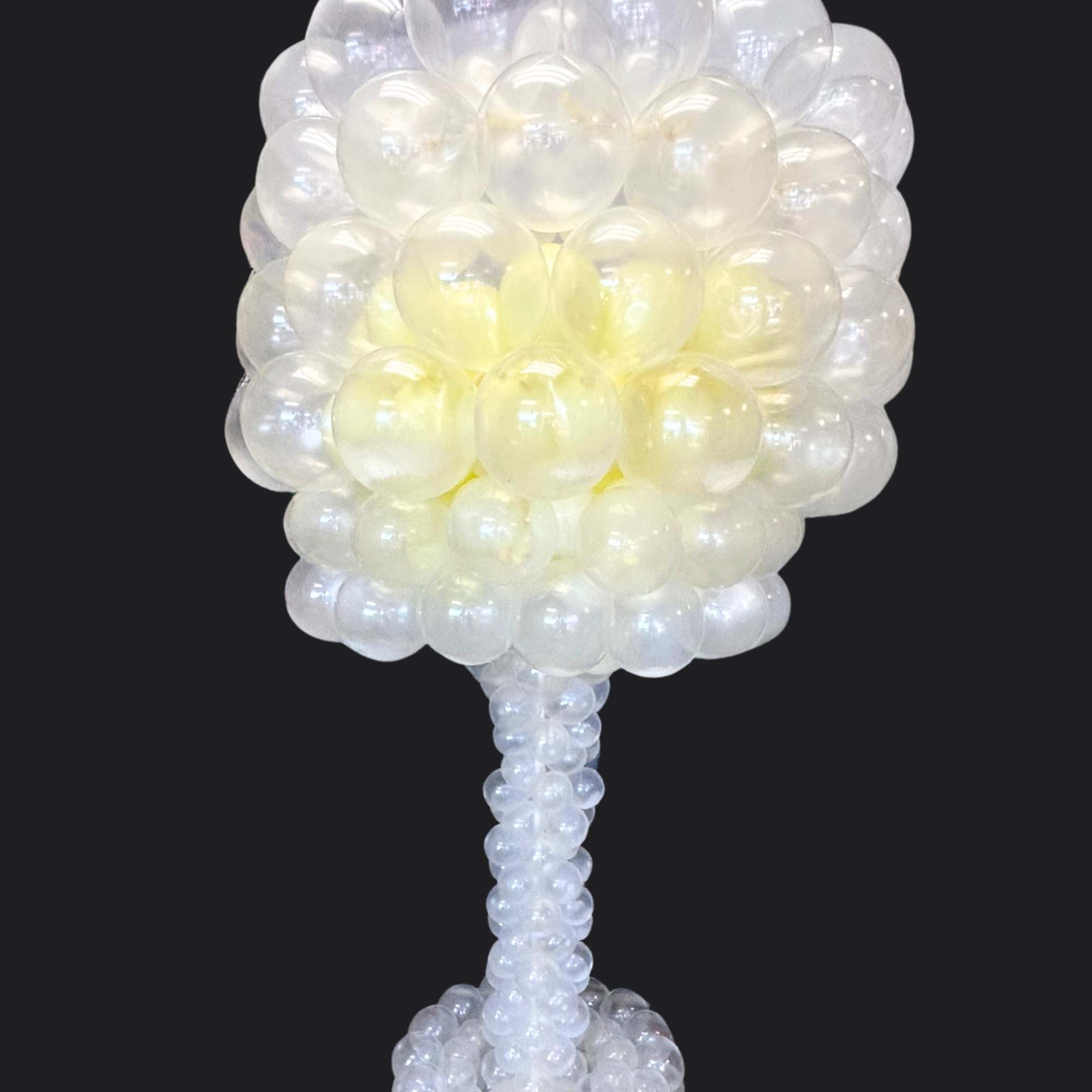 White and pale yellow balloon arrangement on a pedestal base