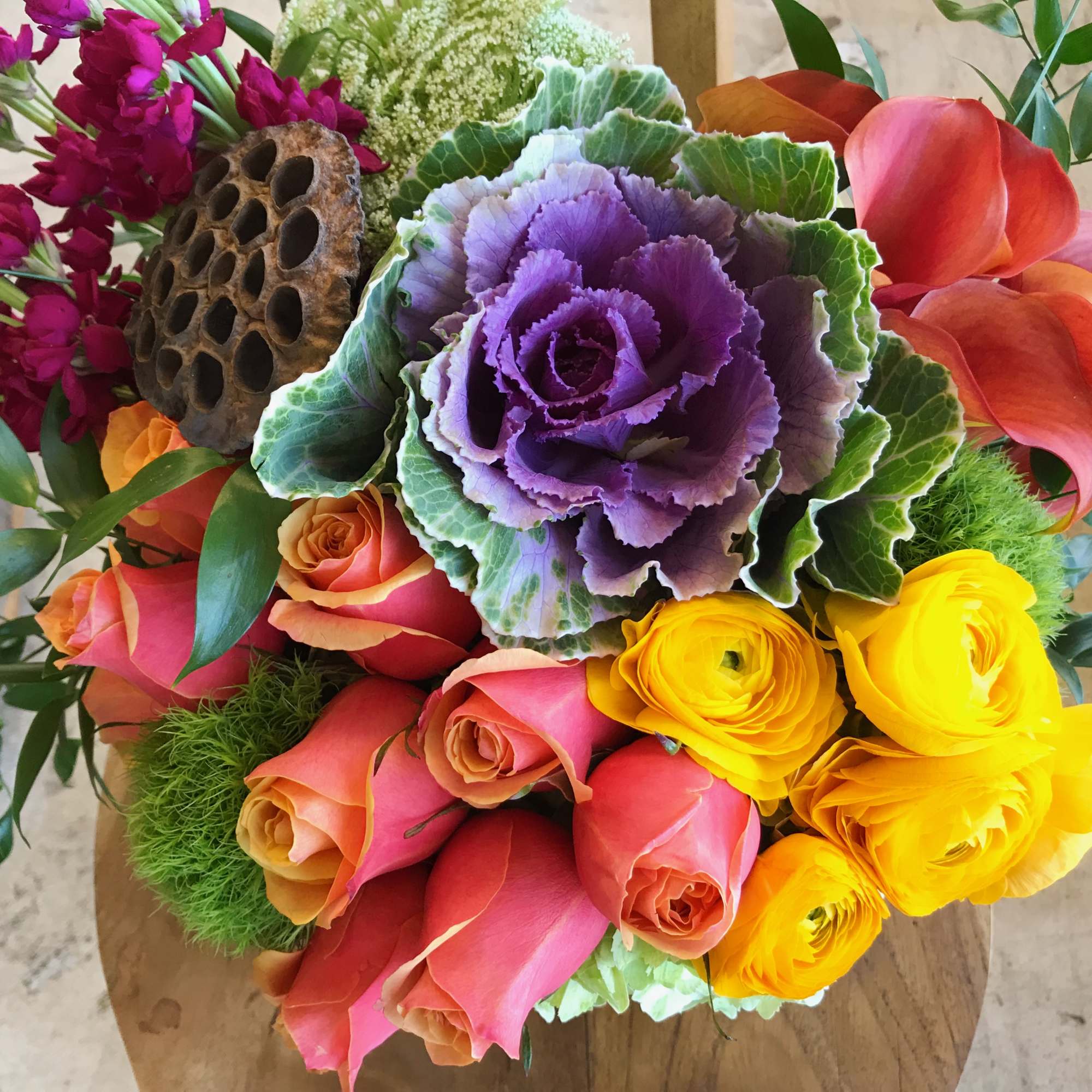 Colorful bouquet with roses, ranunculus, and ornamental cabbage