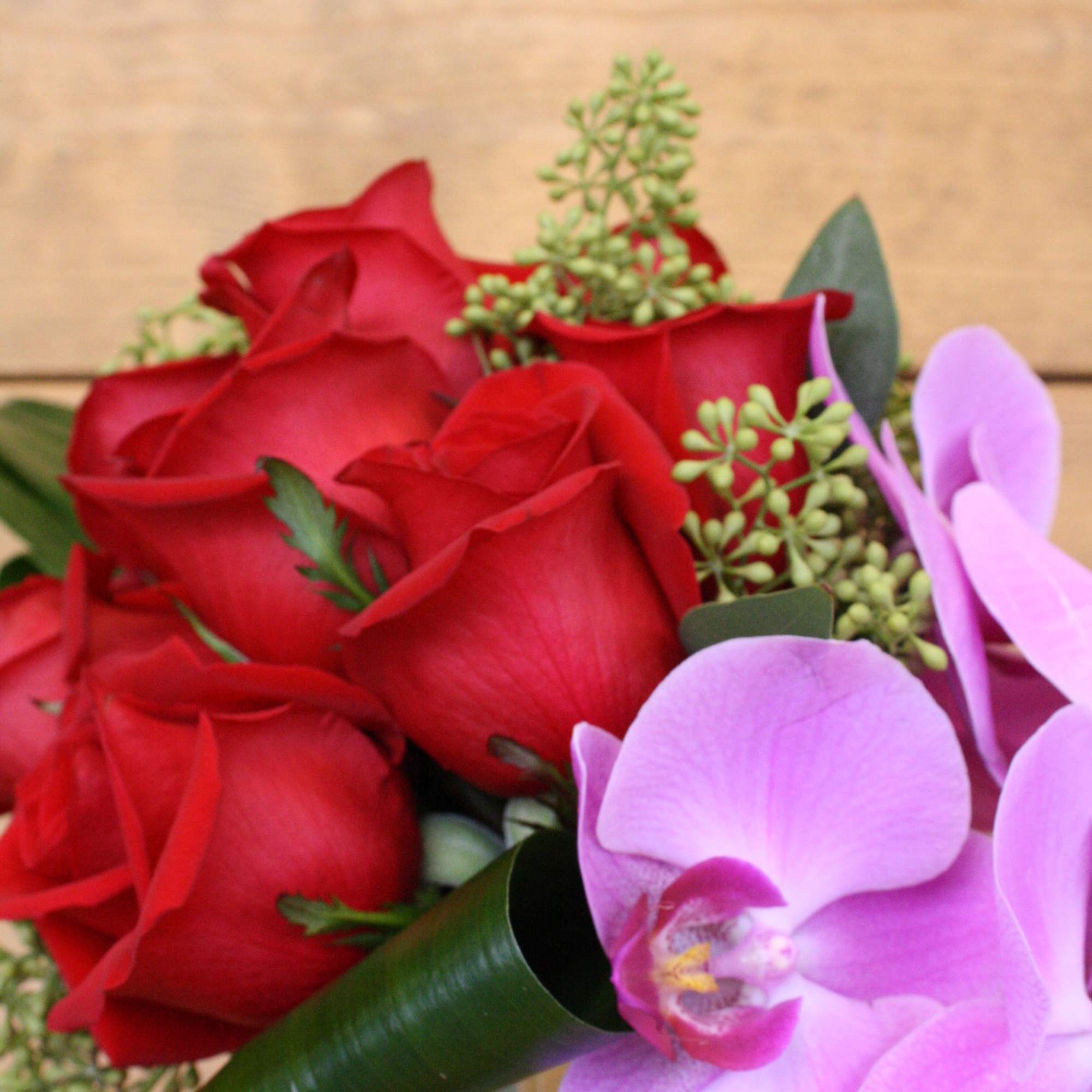 Red roses with pink orchids in a bouquet