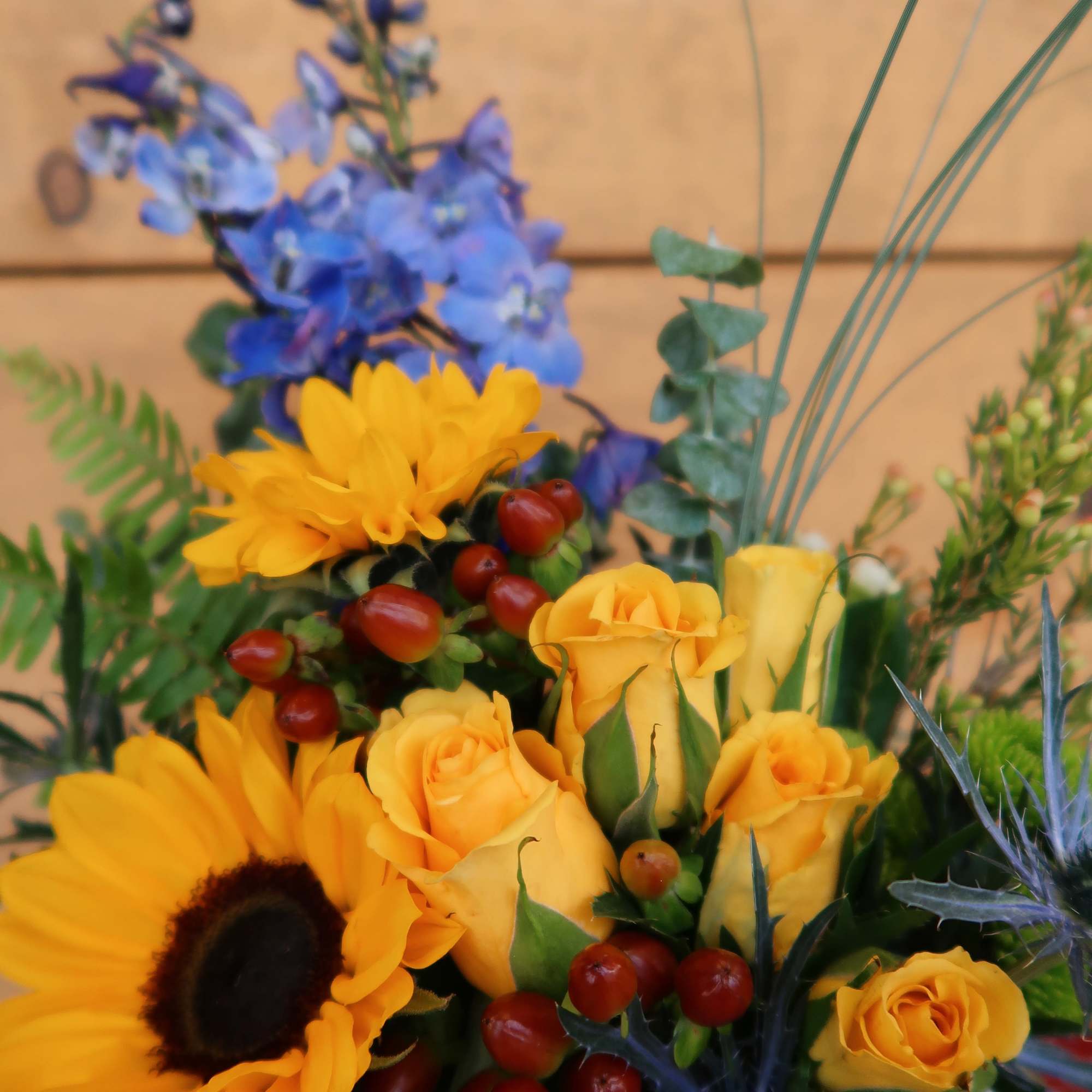 Bouquet with yellow roses, sunflowers, and blue flowers