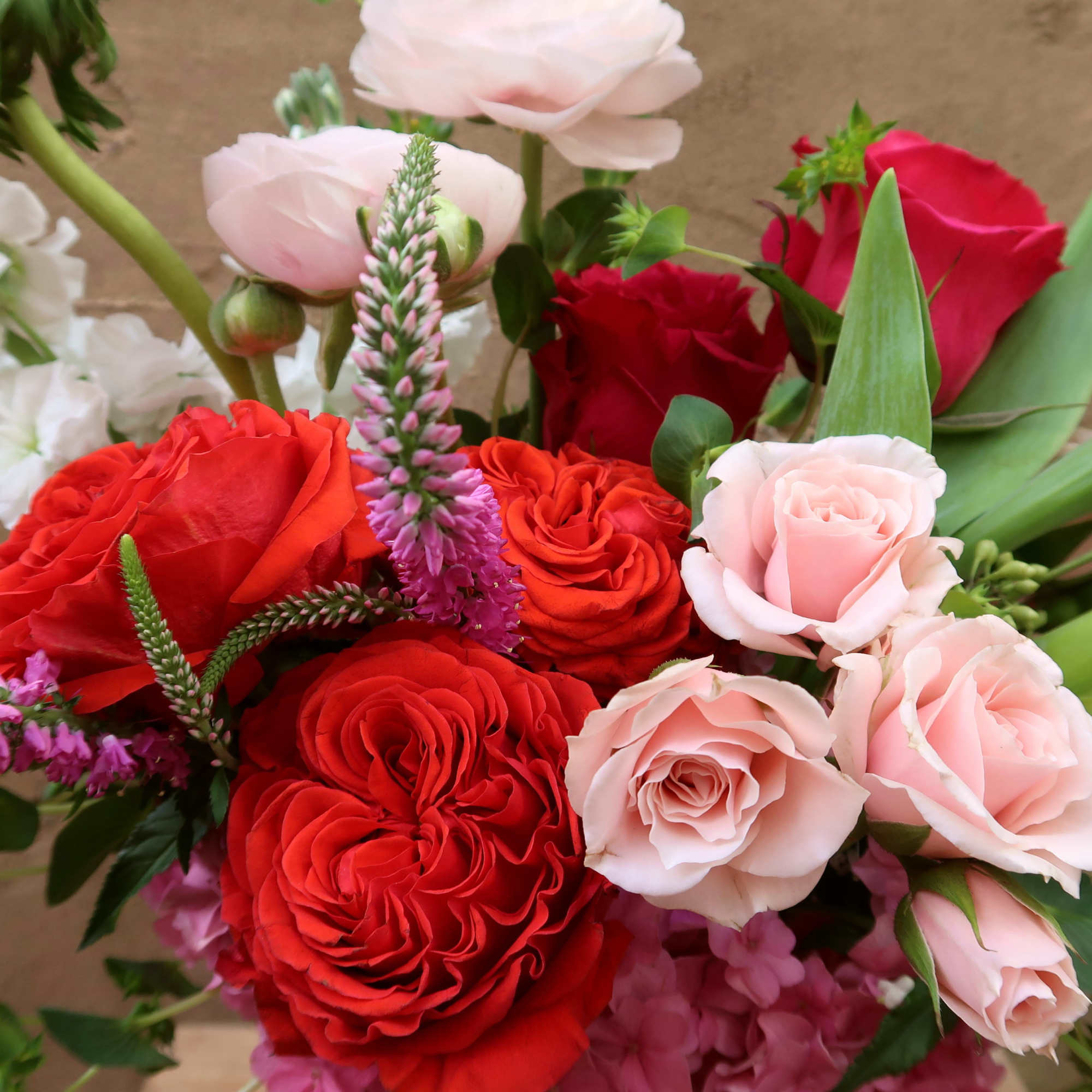 Bouquet of red and pale pink roses with white and purple accents
