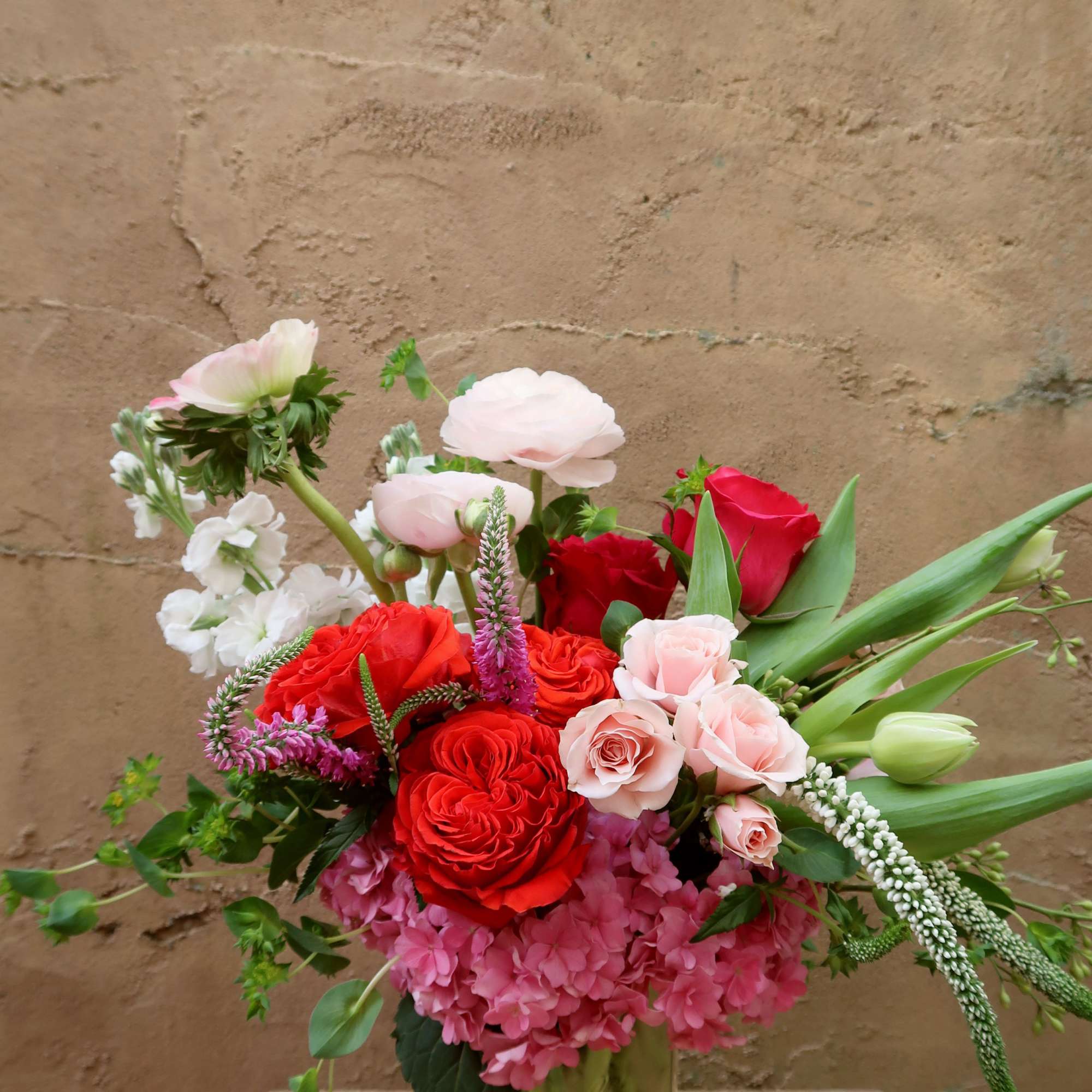 Mixed bouquet of red and pale pink roses in a glass vase