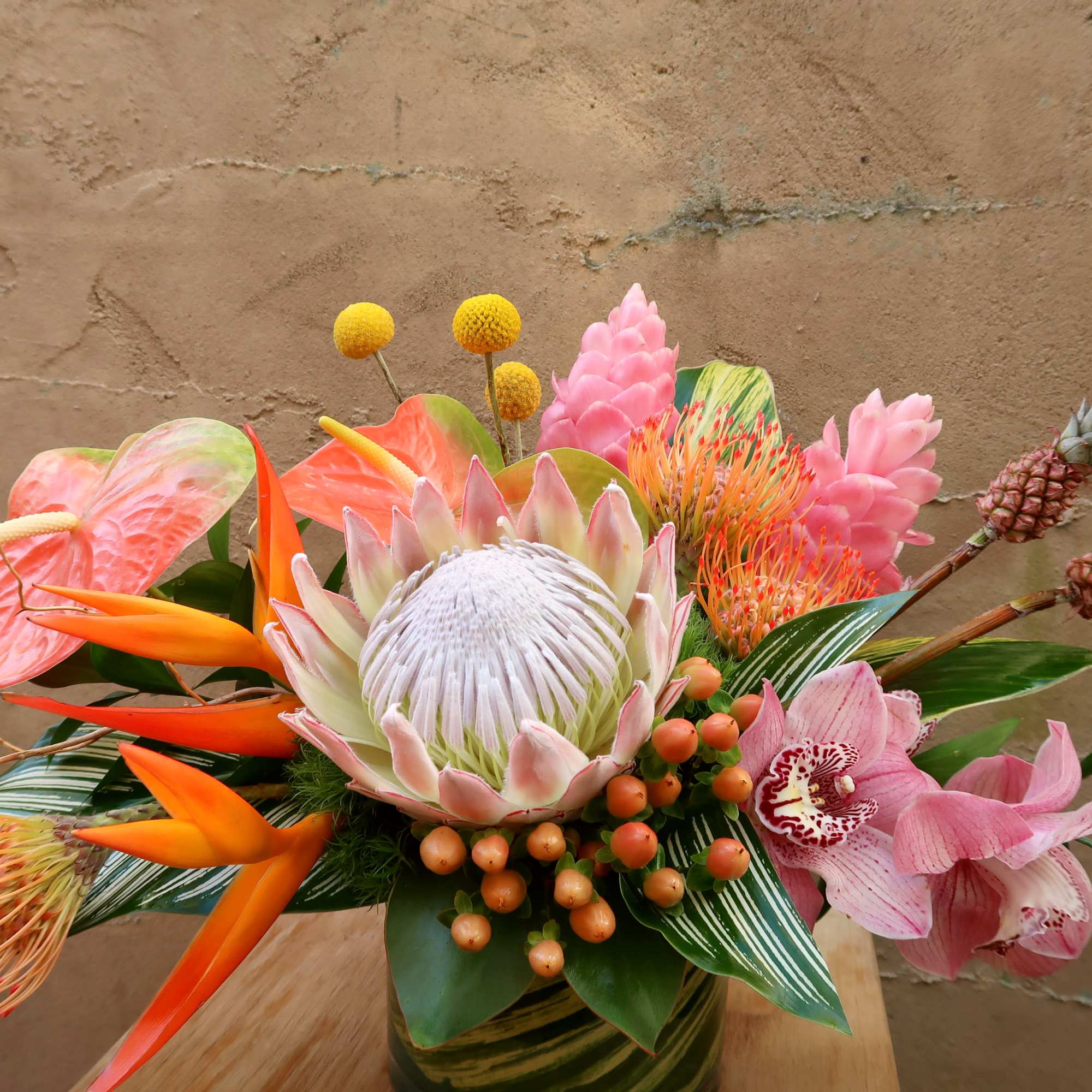 Tropical floral arrangement with pink and orange blooms in a vase