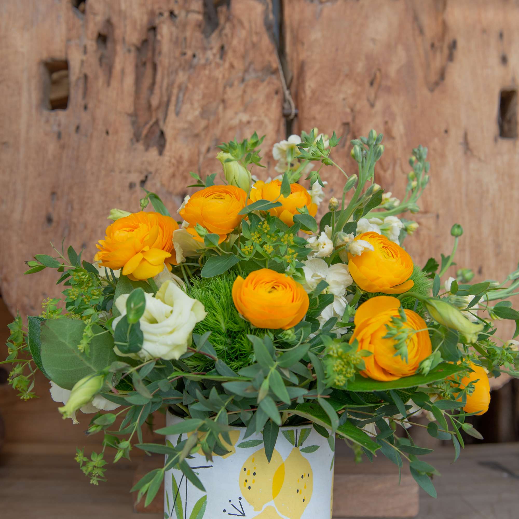 Yellow and white flowers arranged in a patterned ceramic vase