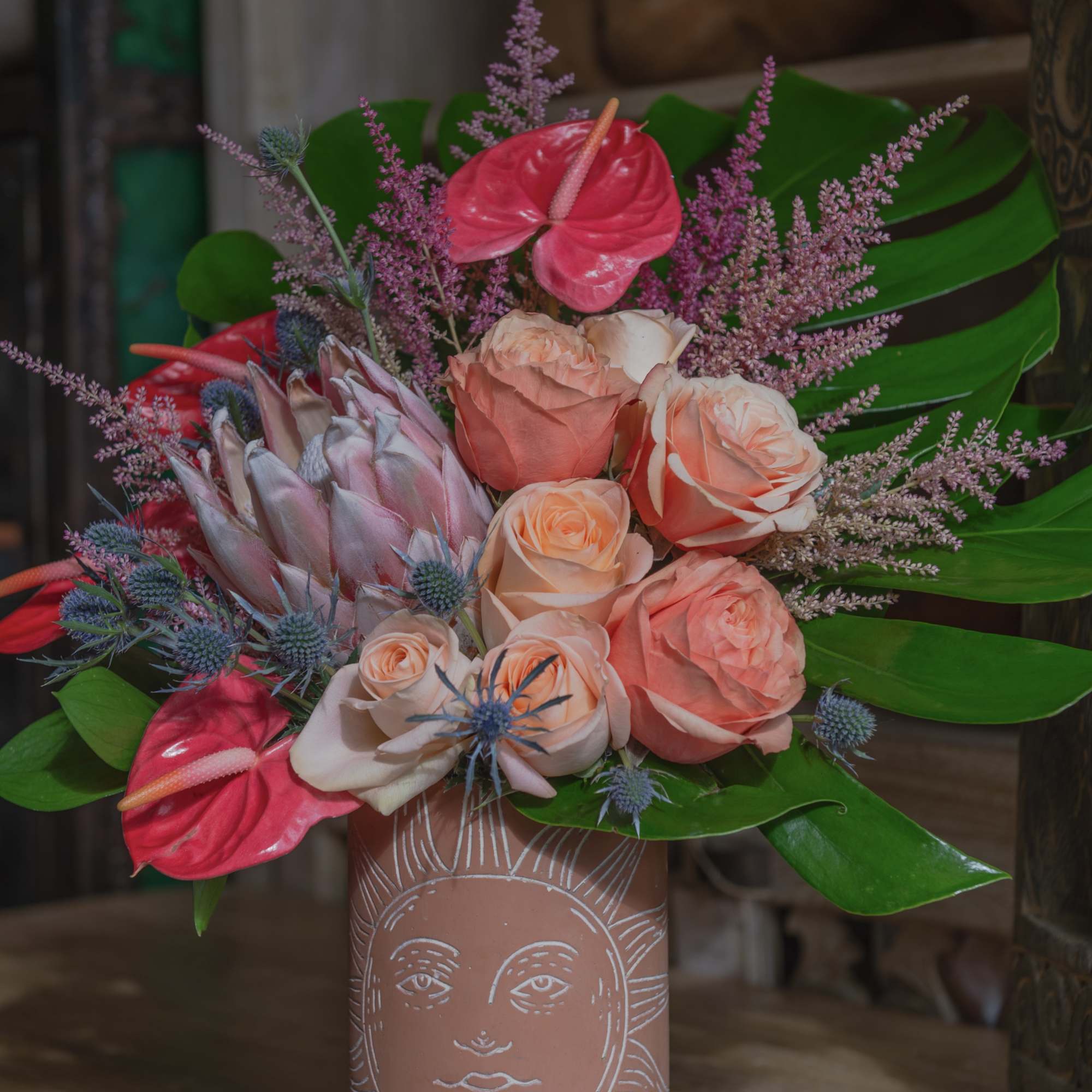 Bouquet of pink roses and anthuriums in a decorated vase