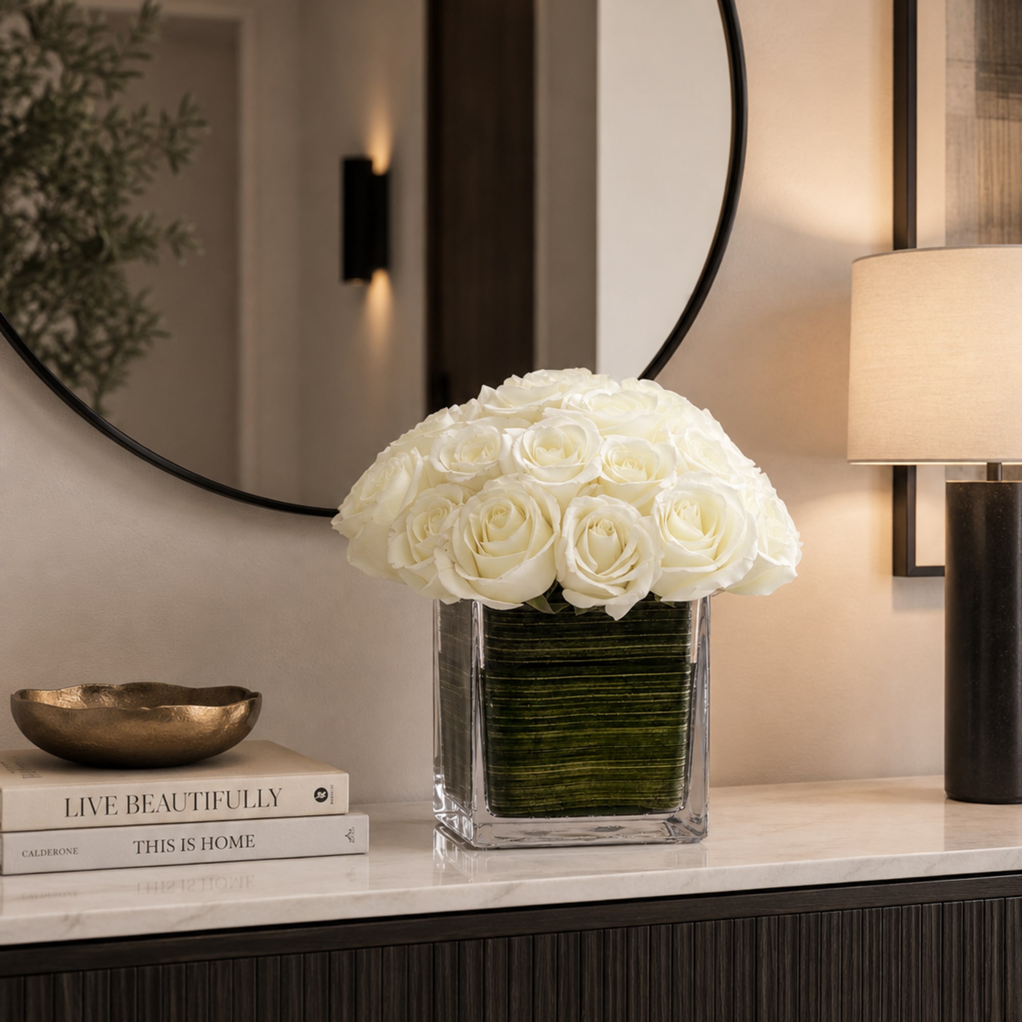 White rose arrangement in a clear square vase on a console table
