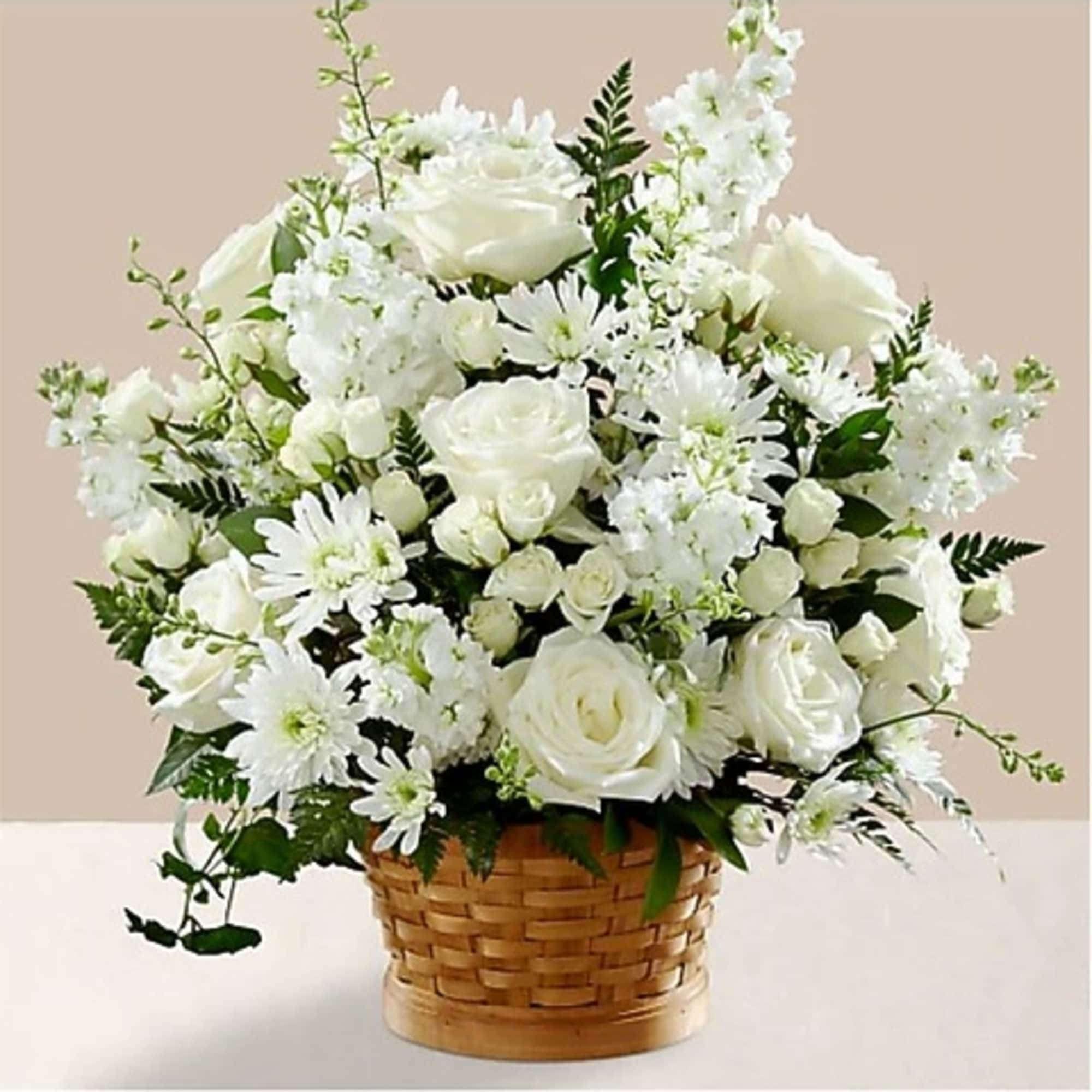 White roses and daisies arranged in a woven basket