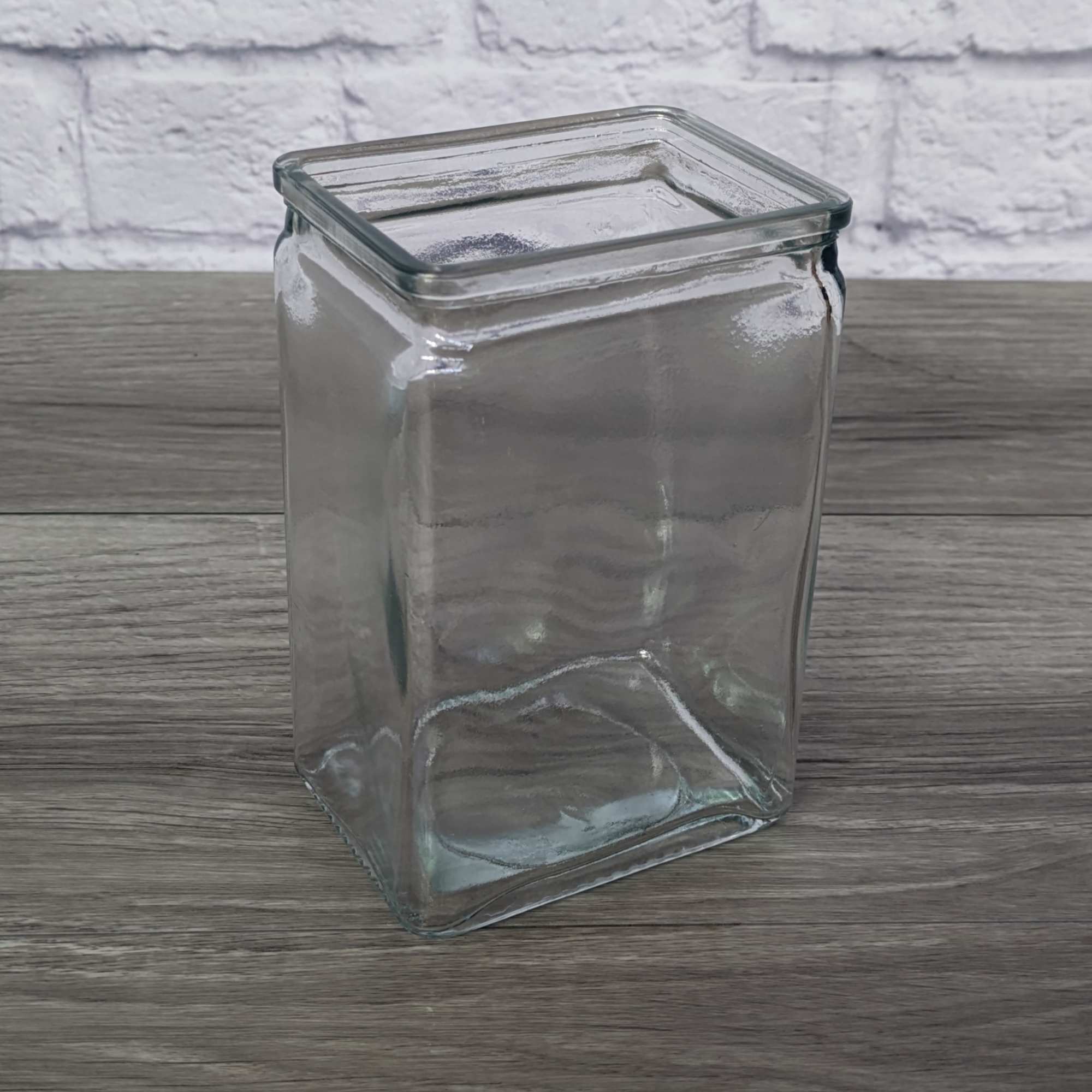 Empty square glass vase on a wooden surface