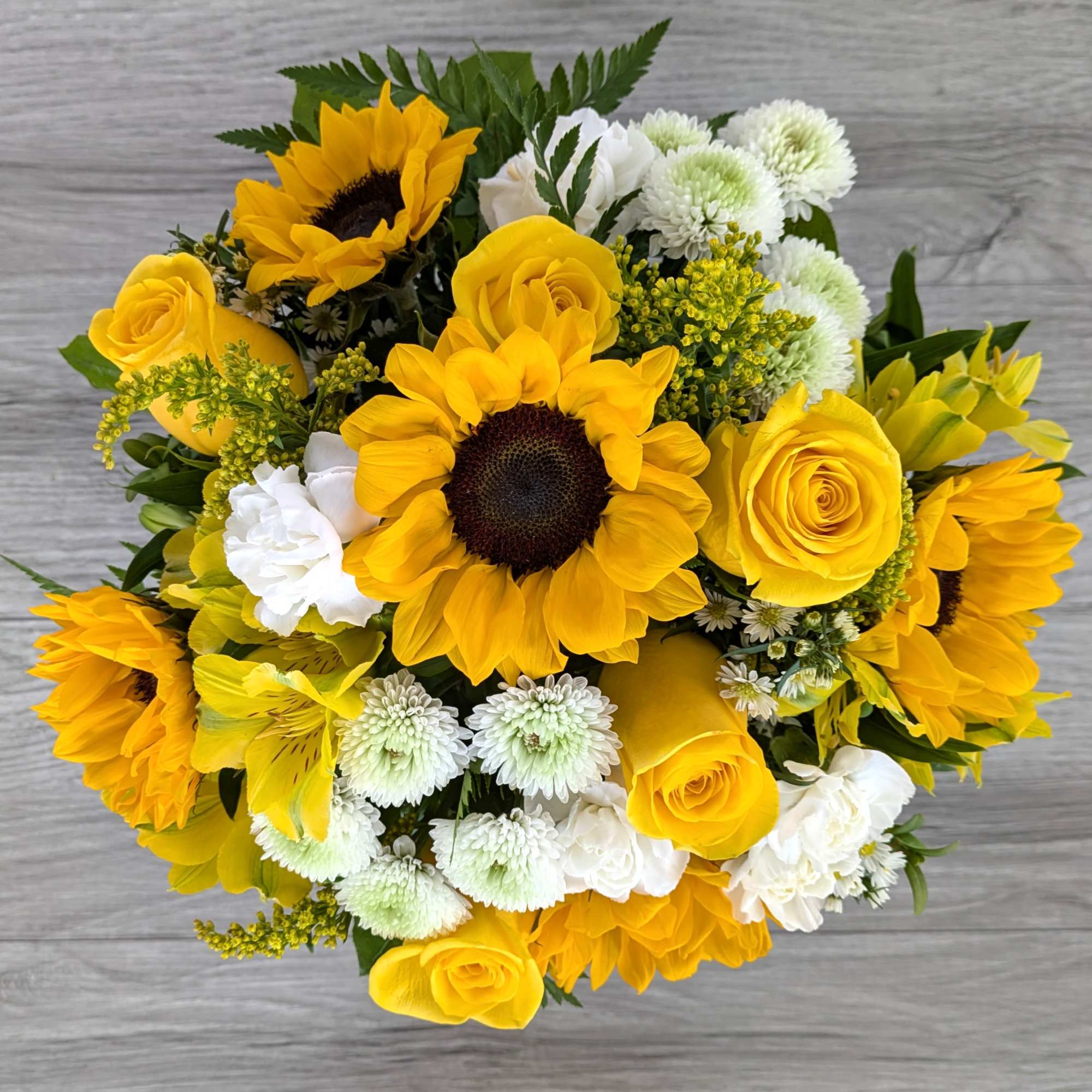Yellow sunflowers and roses with white mums in a bouquet