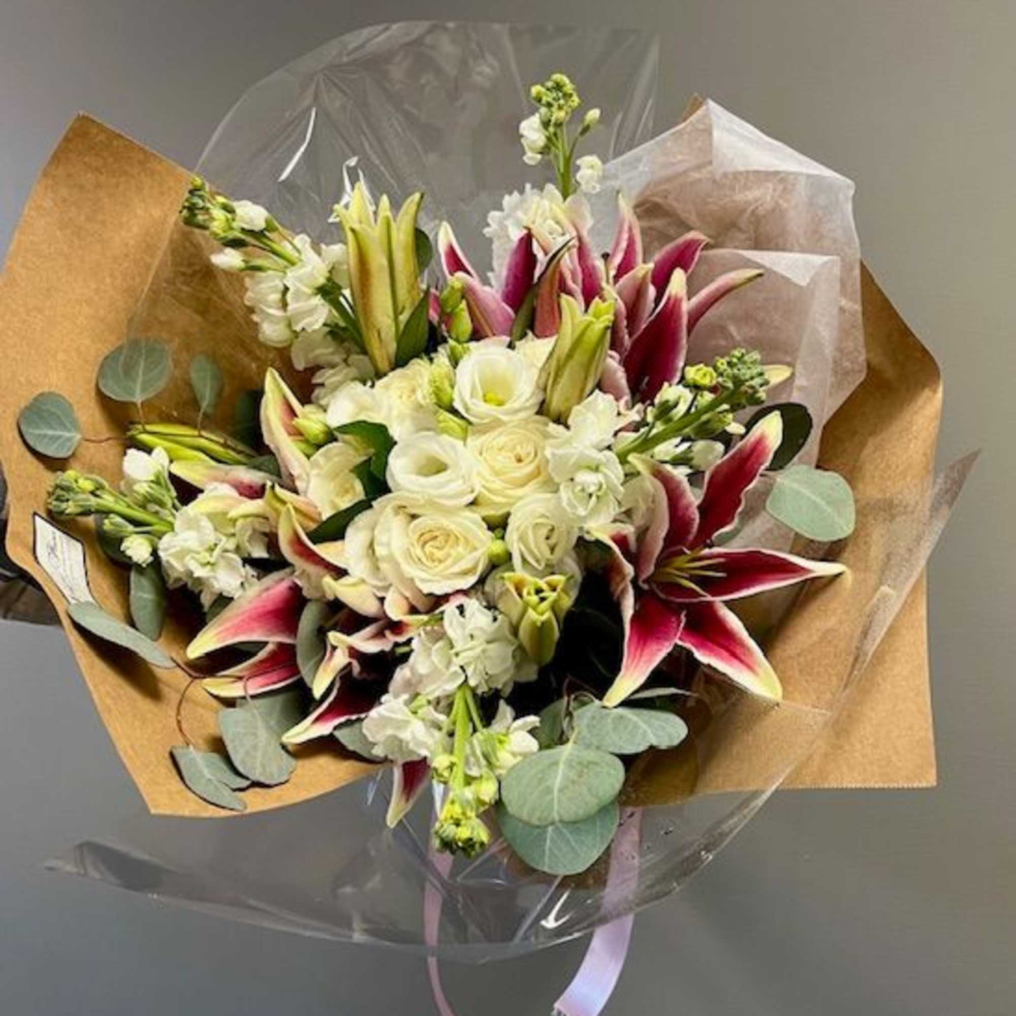 Wrapped bouquet of white roses, lilies. &amp; other mixed white flowers Please