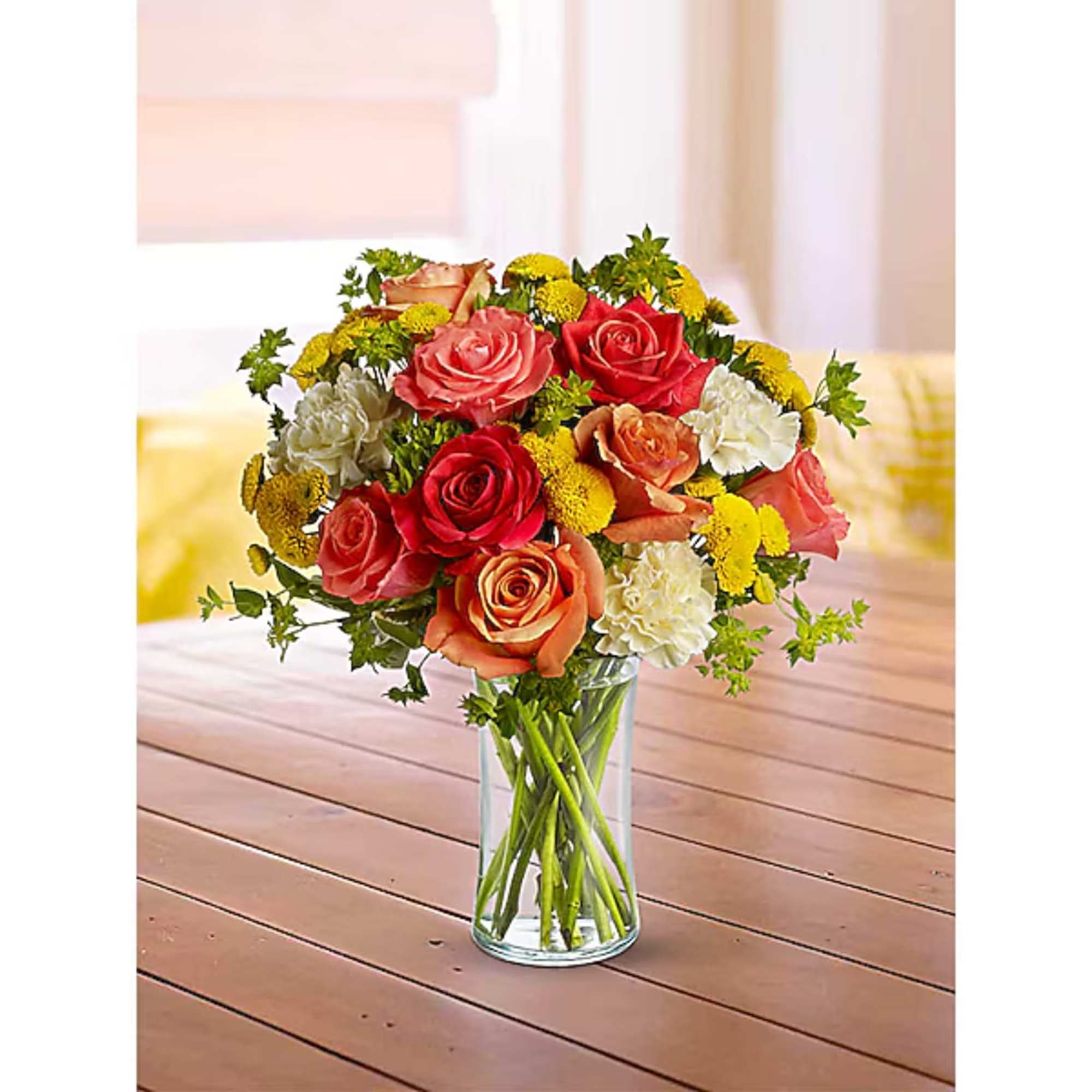 Bouquet of red, pink, and peach roses in a clear glass vase