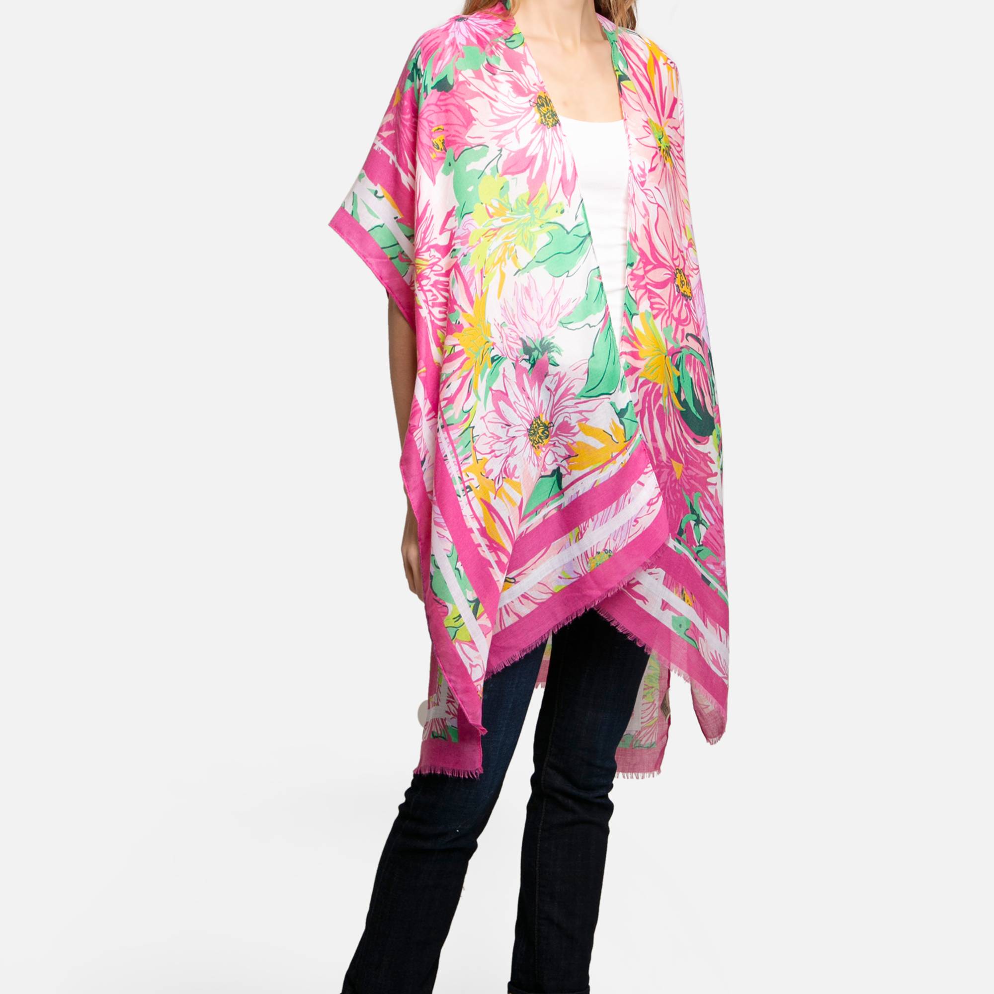 Woman wearing a bright pink floral kimono-style wrap over a white top and jeans