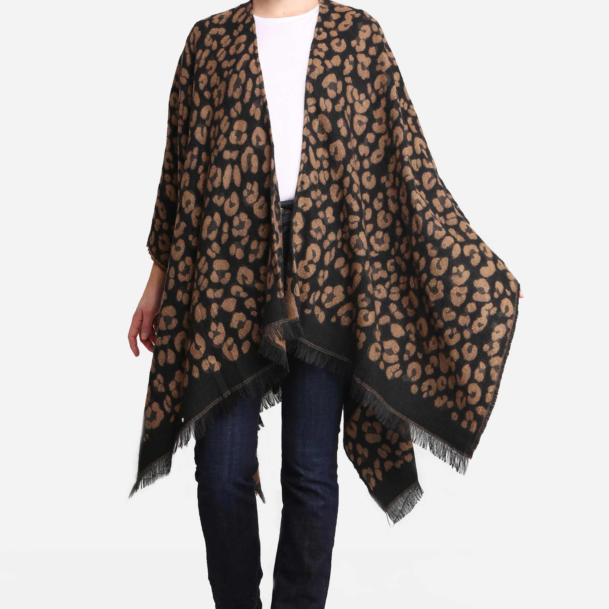 Woman wearing a black and brown leopard print poncho over jeans and a white top.