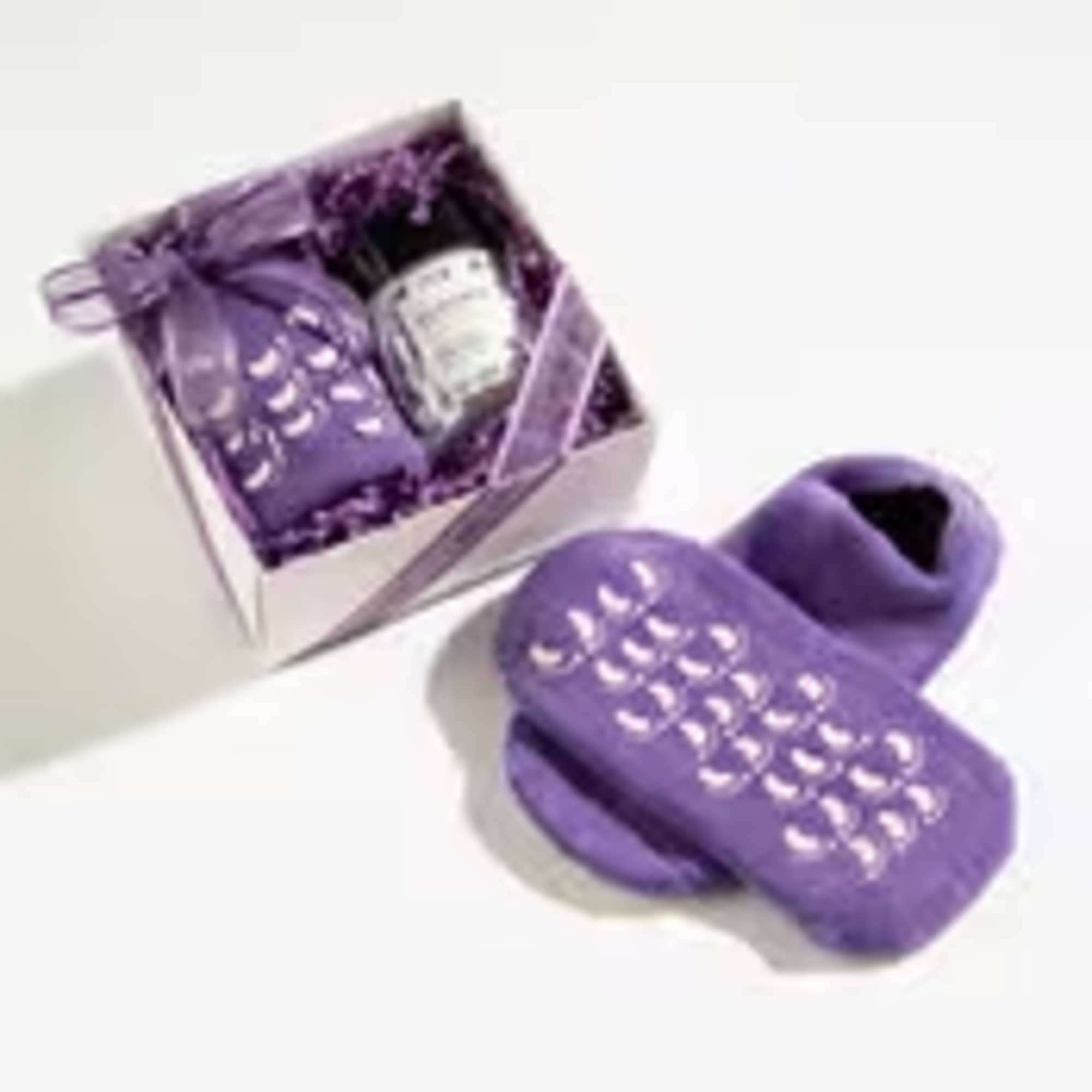 Purple spa gift set with cozy grip socks, candle jar, and sachet in a ribboned box