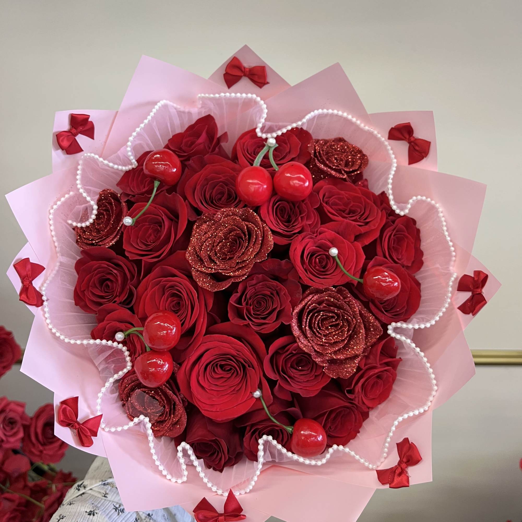 Bouquet of red roses with pink wrapping and red ribbon bows