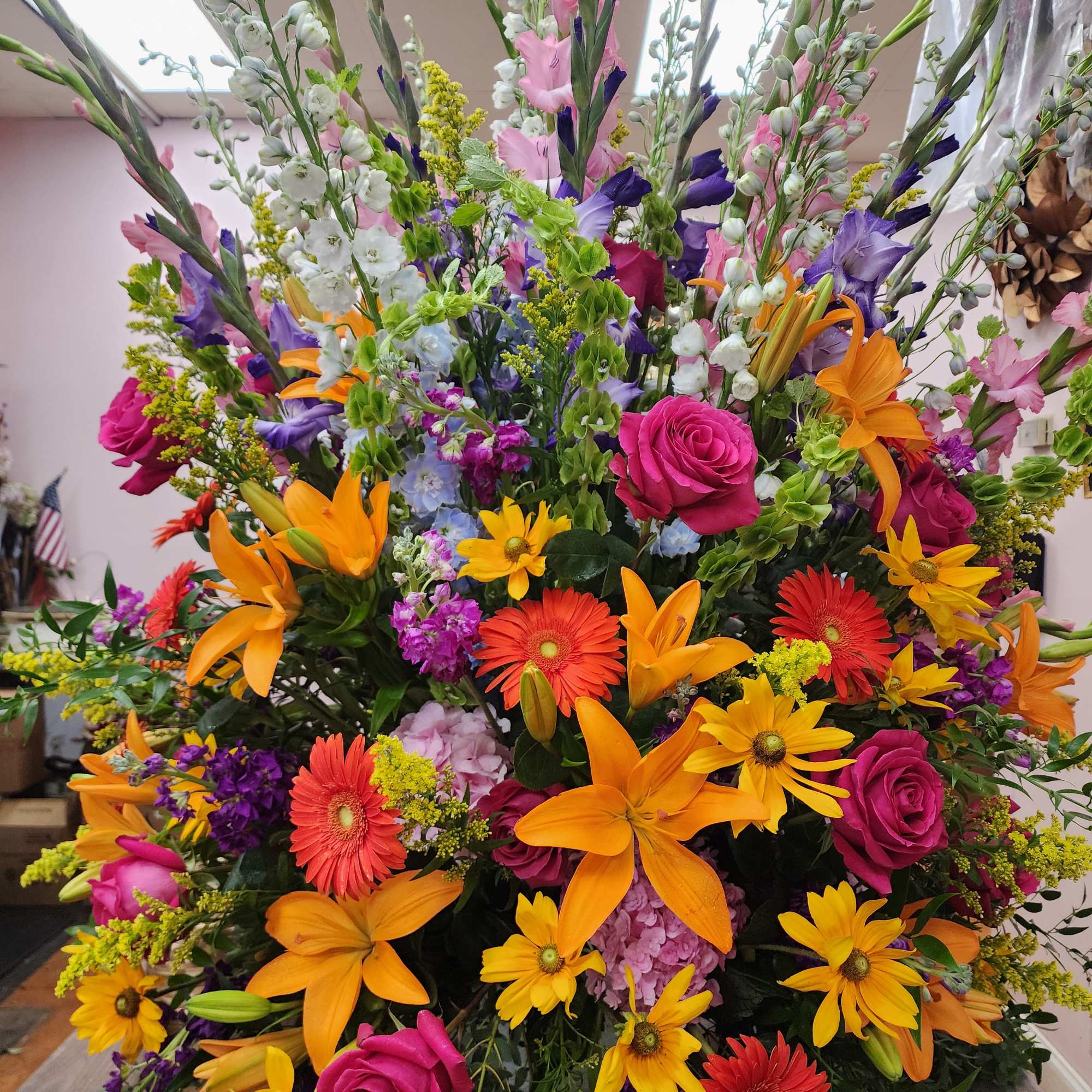 Large mixed flower arrangement with orange lilies, pink roses, and gerbera daisies
