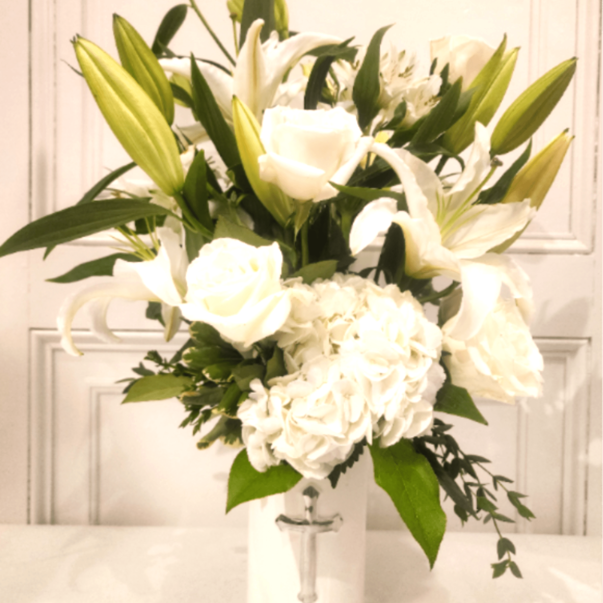 This all-white arrangement of premium flowers is a memorable gesture for any