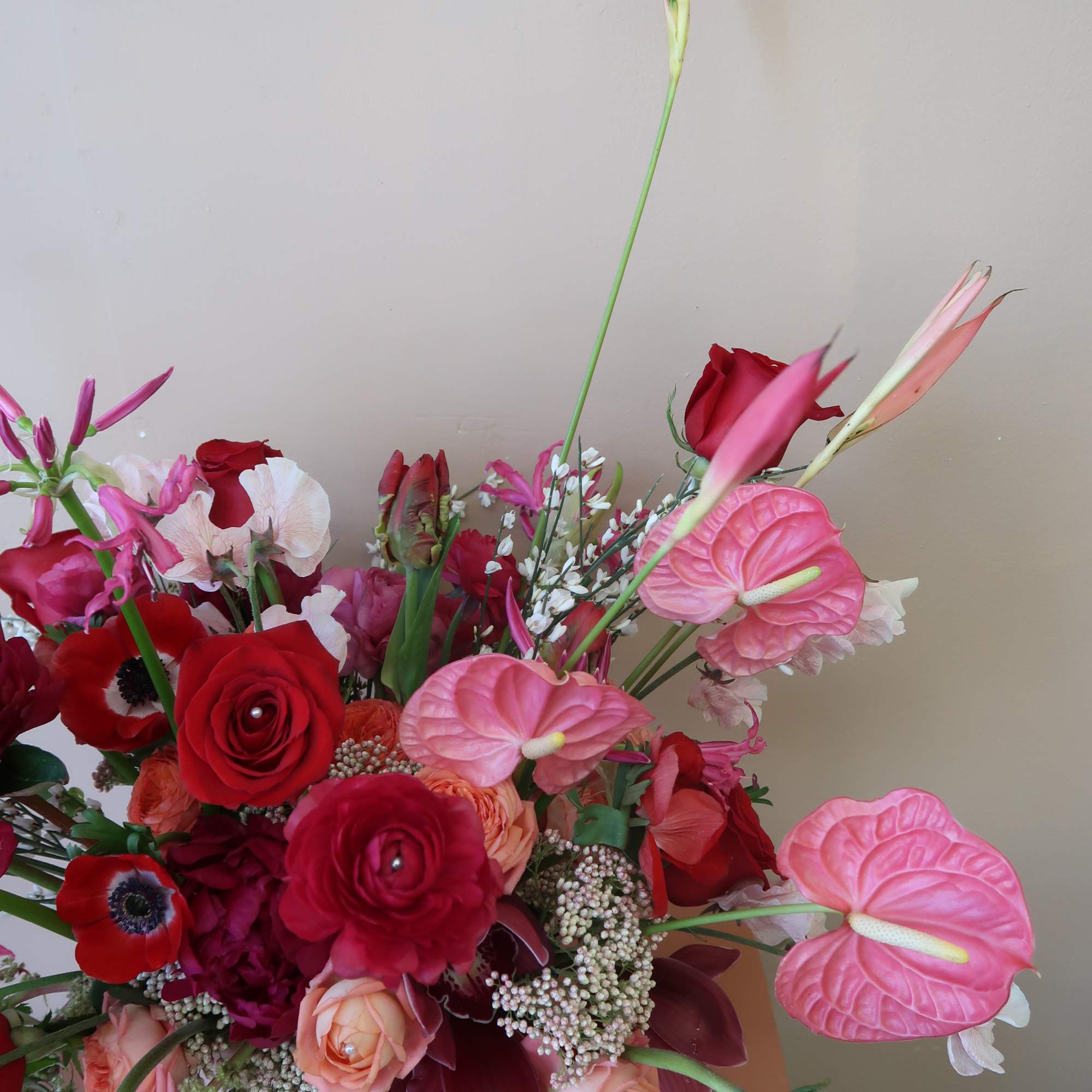 Mixed bouquet with red roses and pink anthuriums in a vase
