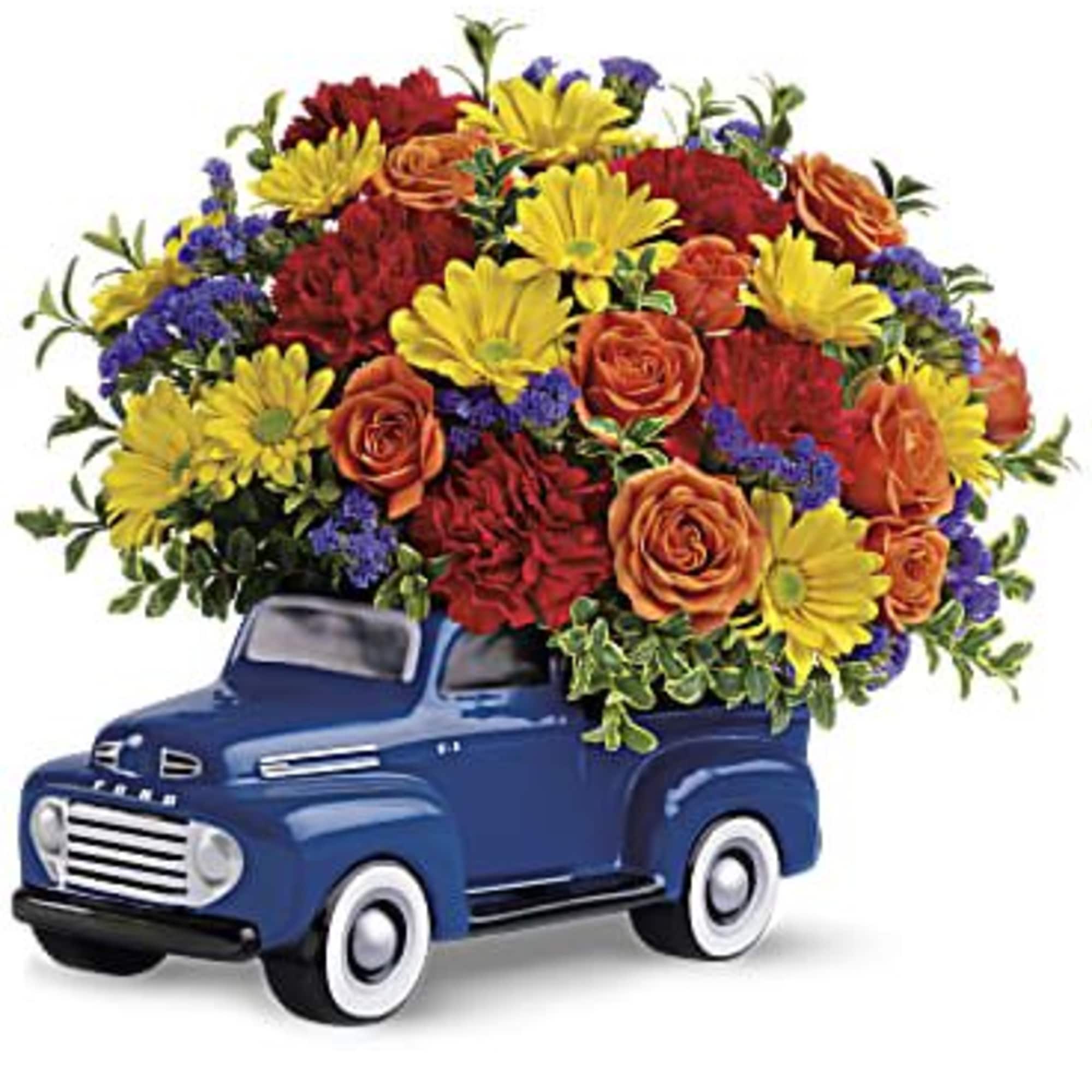 Bouquet of yellow, orange, red, and purple flowers in a blue truck container