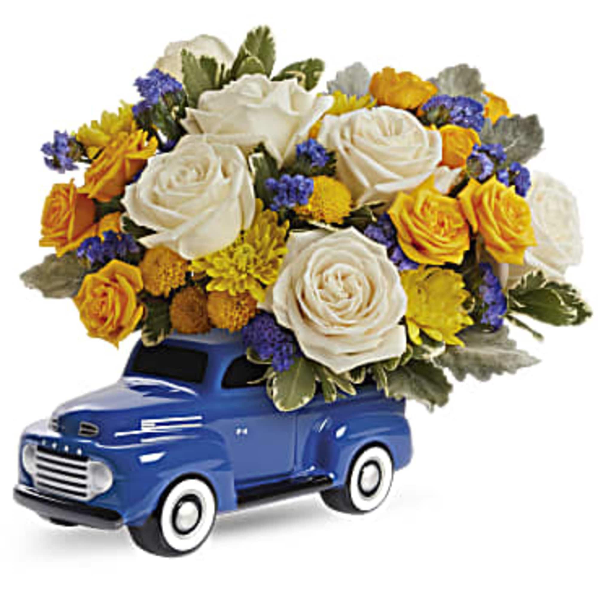 Blue toy truck topped with white, yellow, and purple flowers