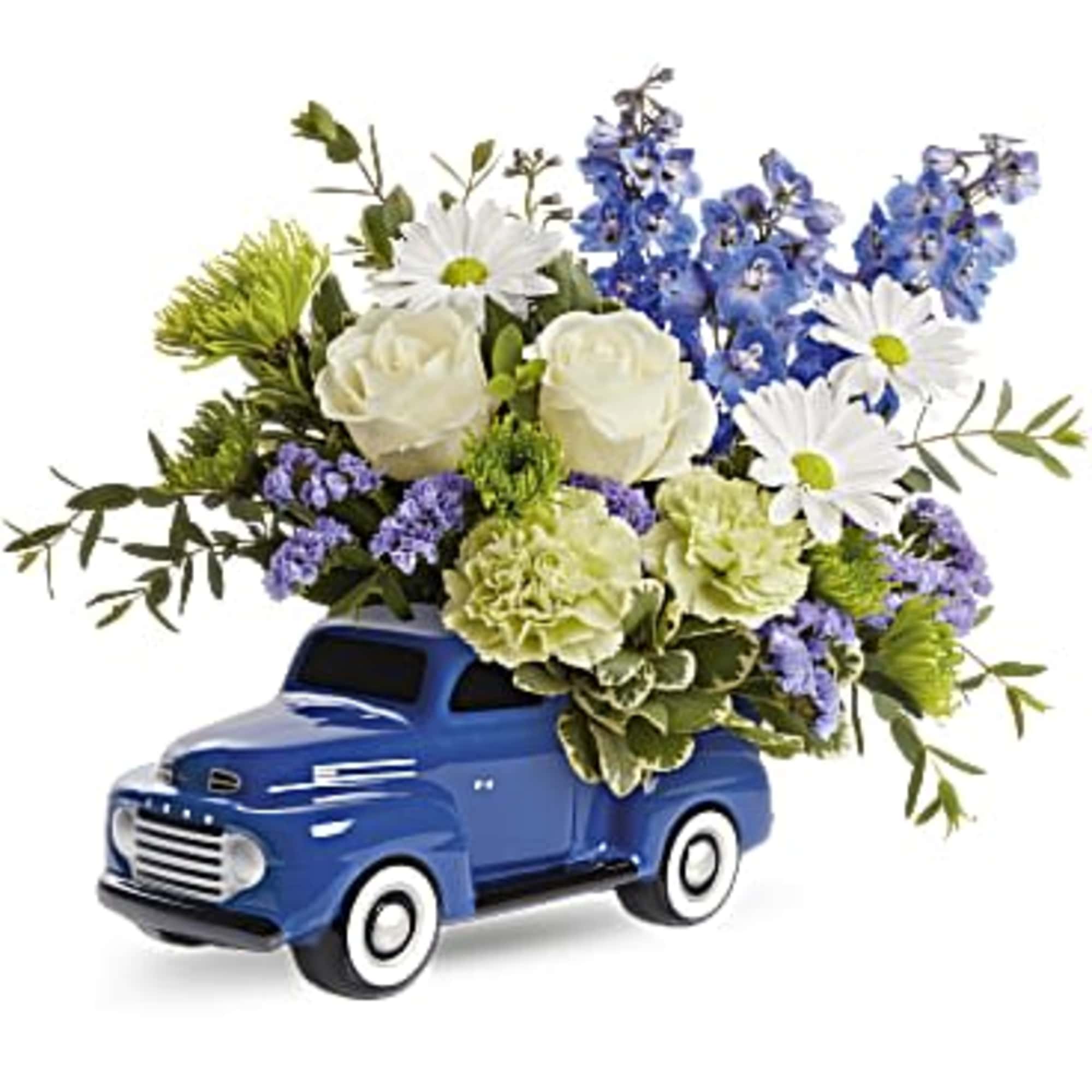 Blue toy truck holding white and blue flowers